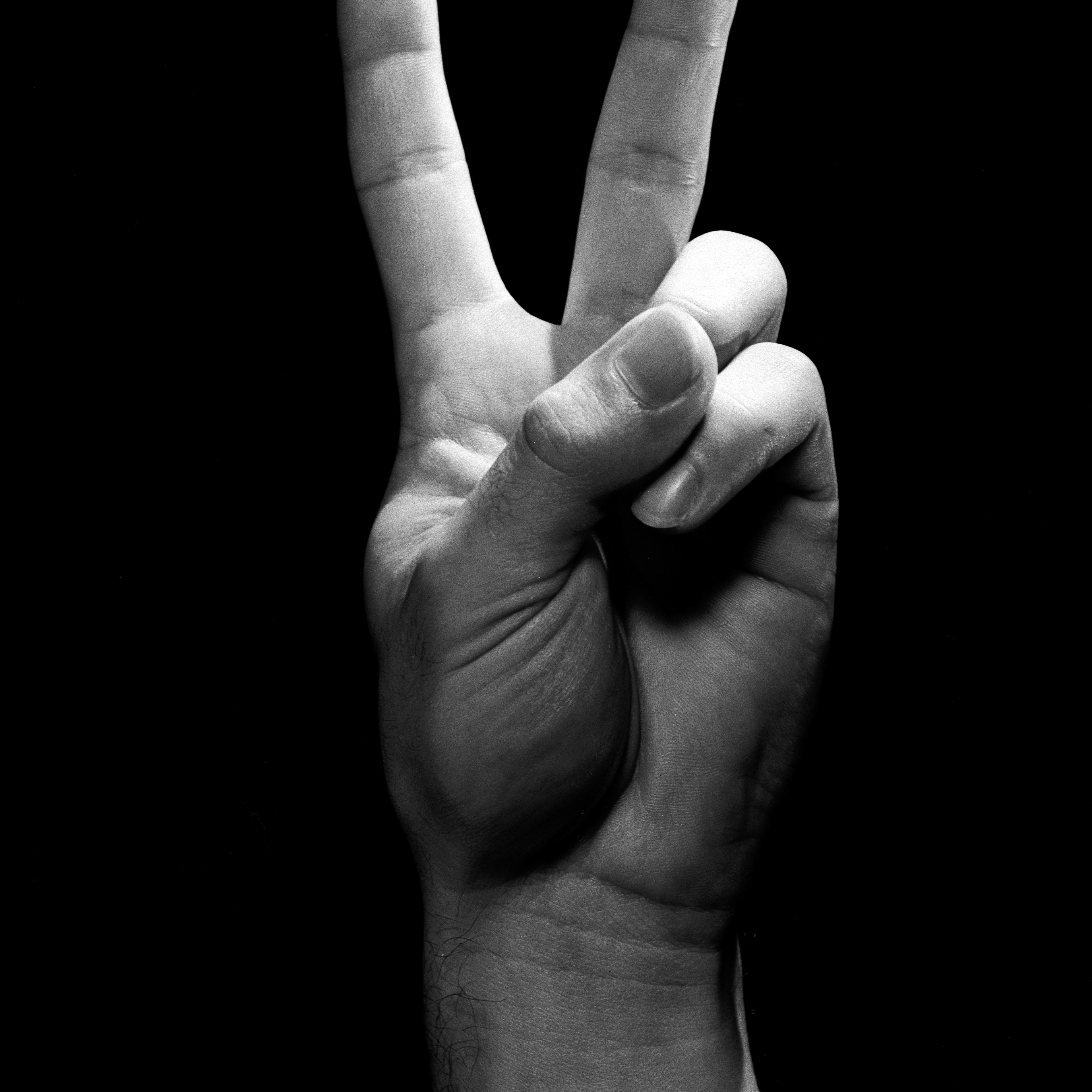 Studio shot of male hand showing peace sign
