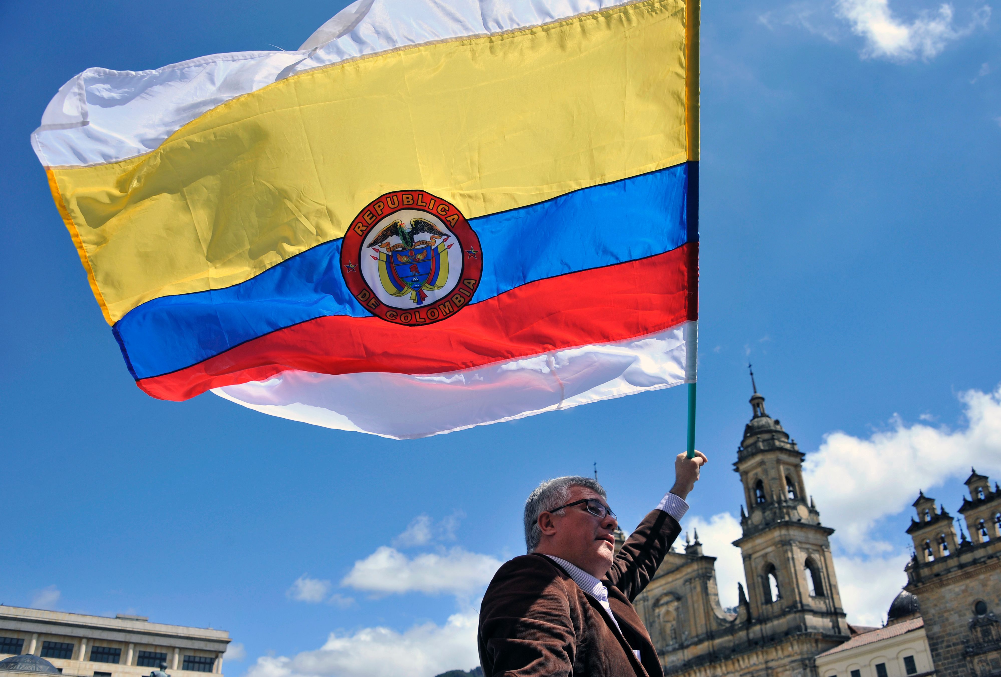A man holds a Colombian national flag with white stripes during a demo to demand the immediate endorsement of the new peace agreement between the Colombian government and the FARC guerrilla outside the Colombian Congress in Bogota, on November 30, 2016.