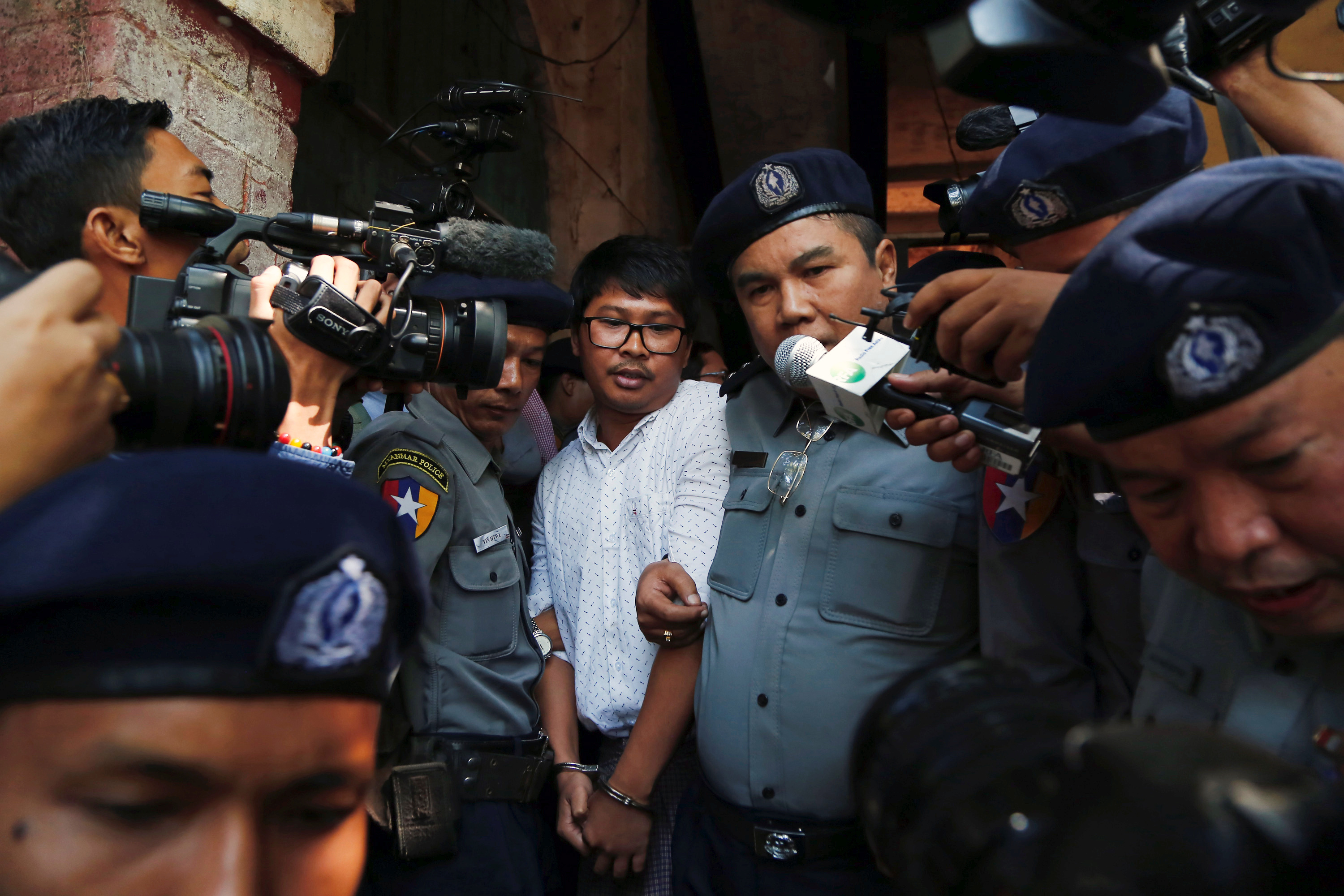 Detained Reuters journalist Wa Lone escorted by police after a court hearing in Yangon