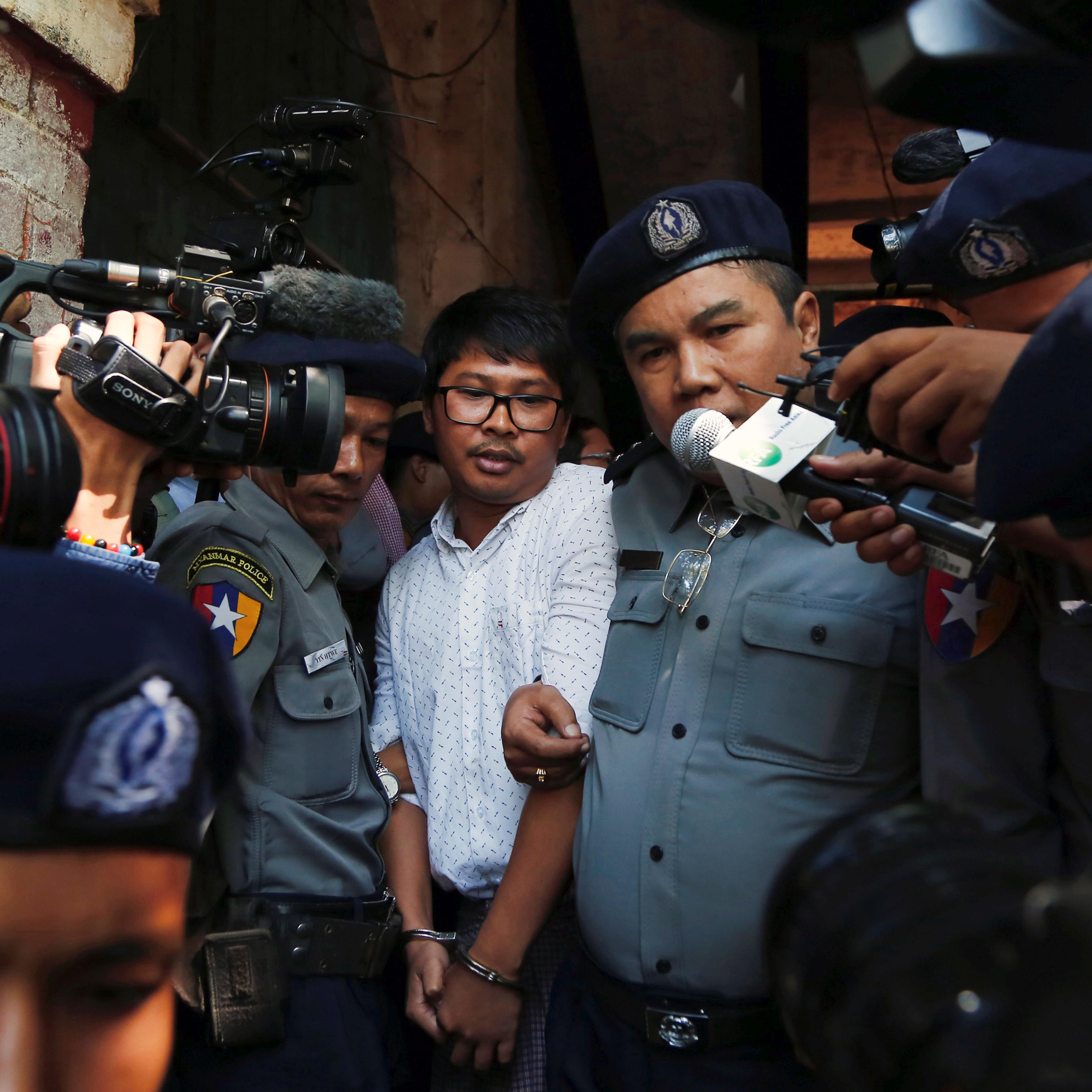 Detained Reuters journalist Wa Lone escorted by police after a court hearing in Yangon