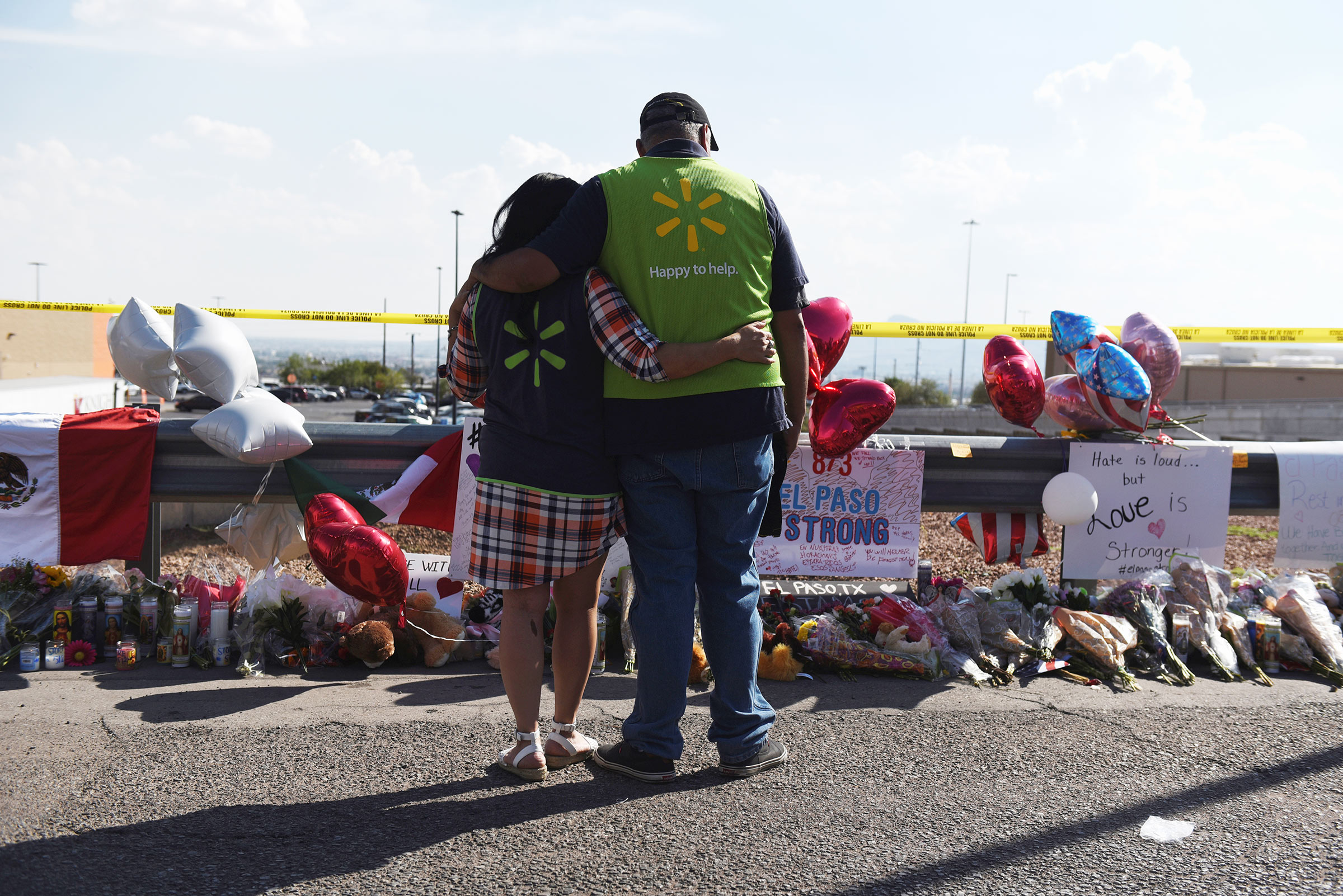 Walmart employees pay their respects at a memorial outside the site of the El Paso mass shooting.