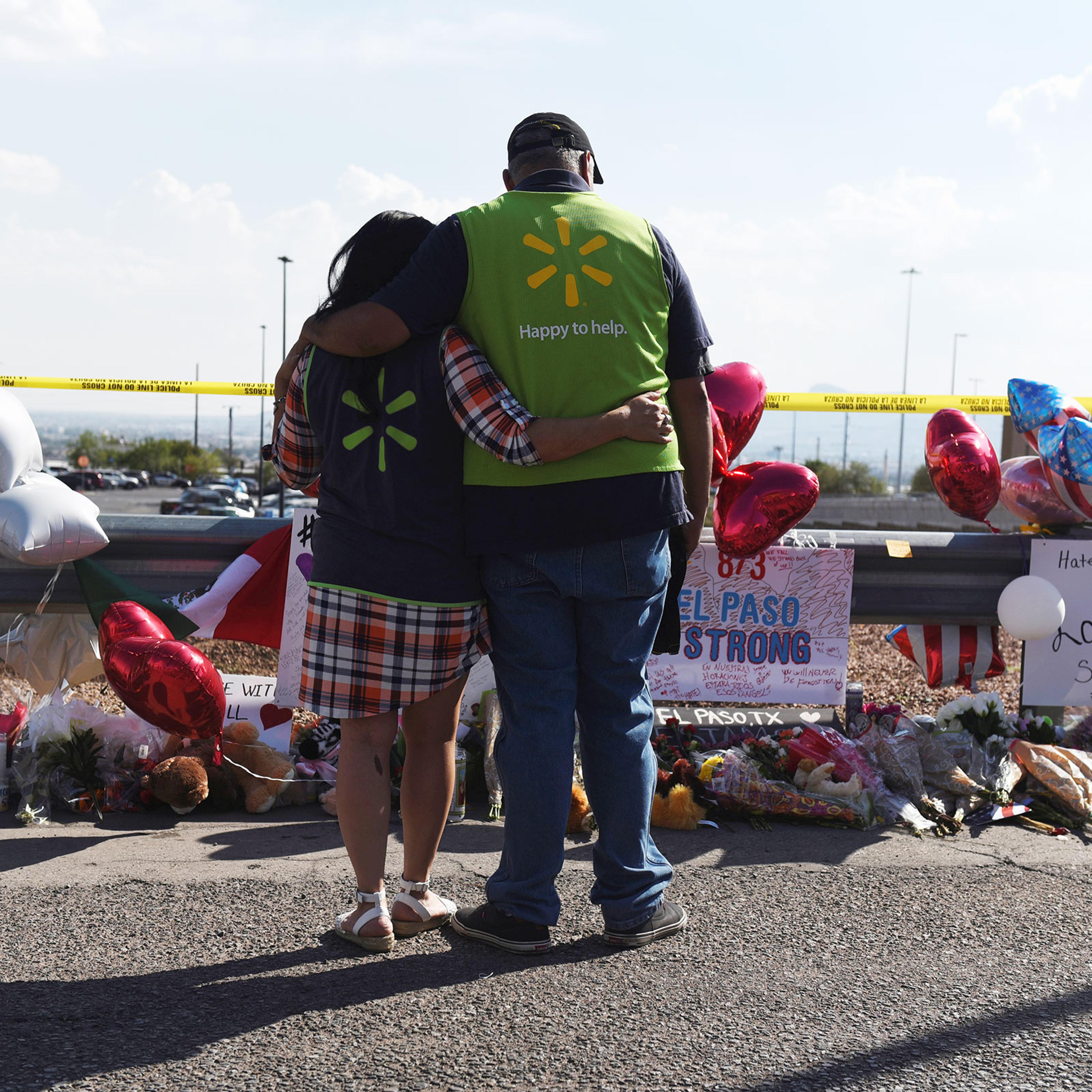 Walmart employees pay their respects at a memorial outside the site of the El Paso mass shooting.