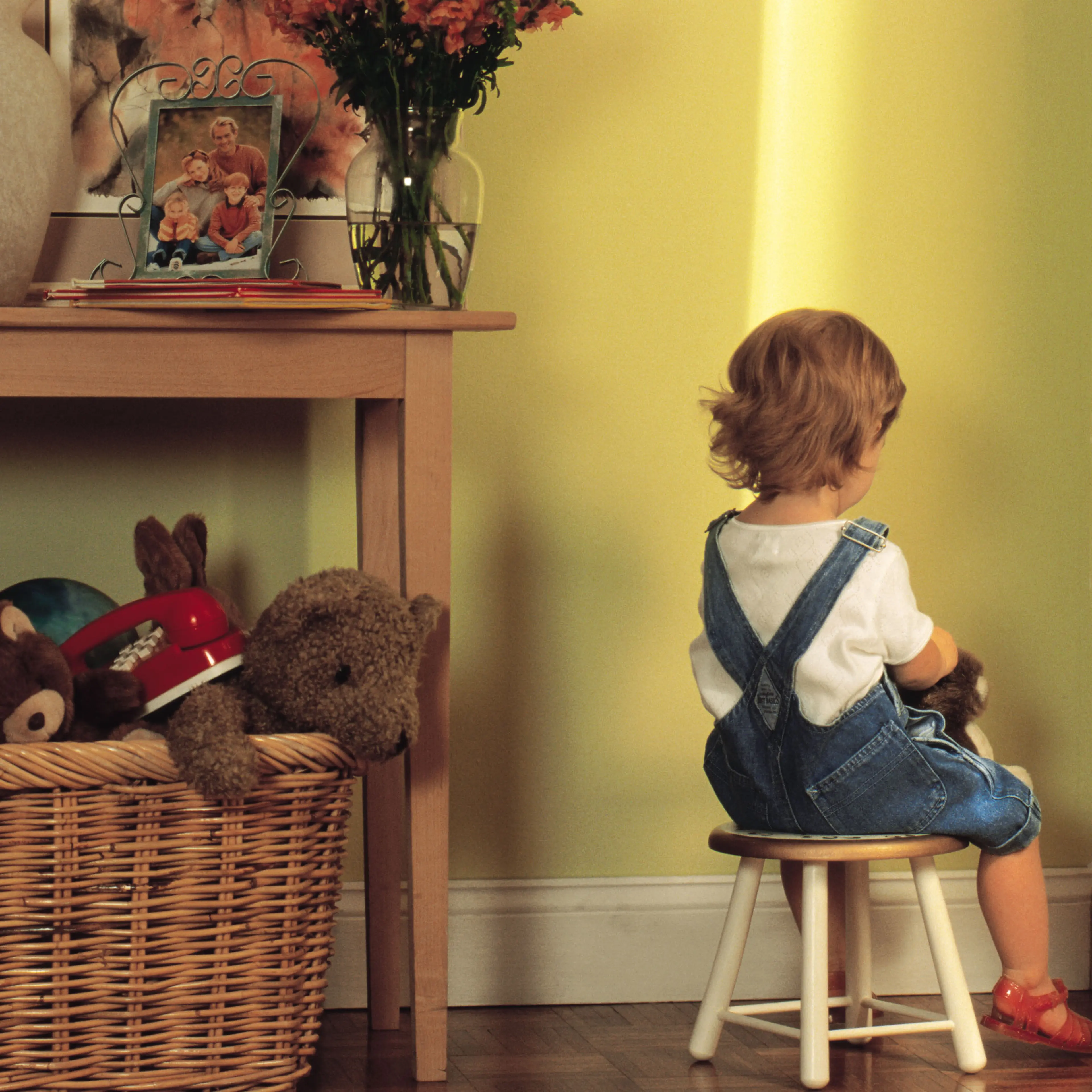 Young child sitting in corner as punishment
