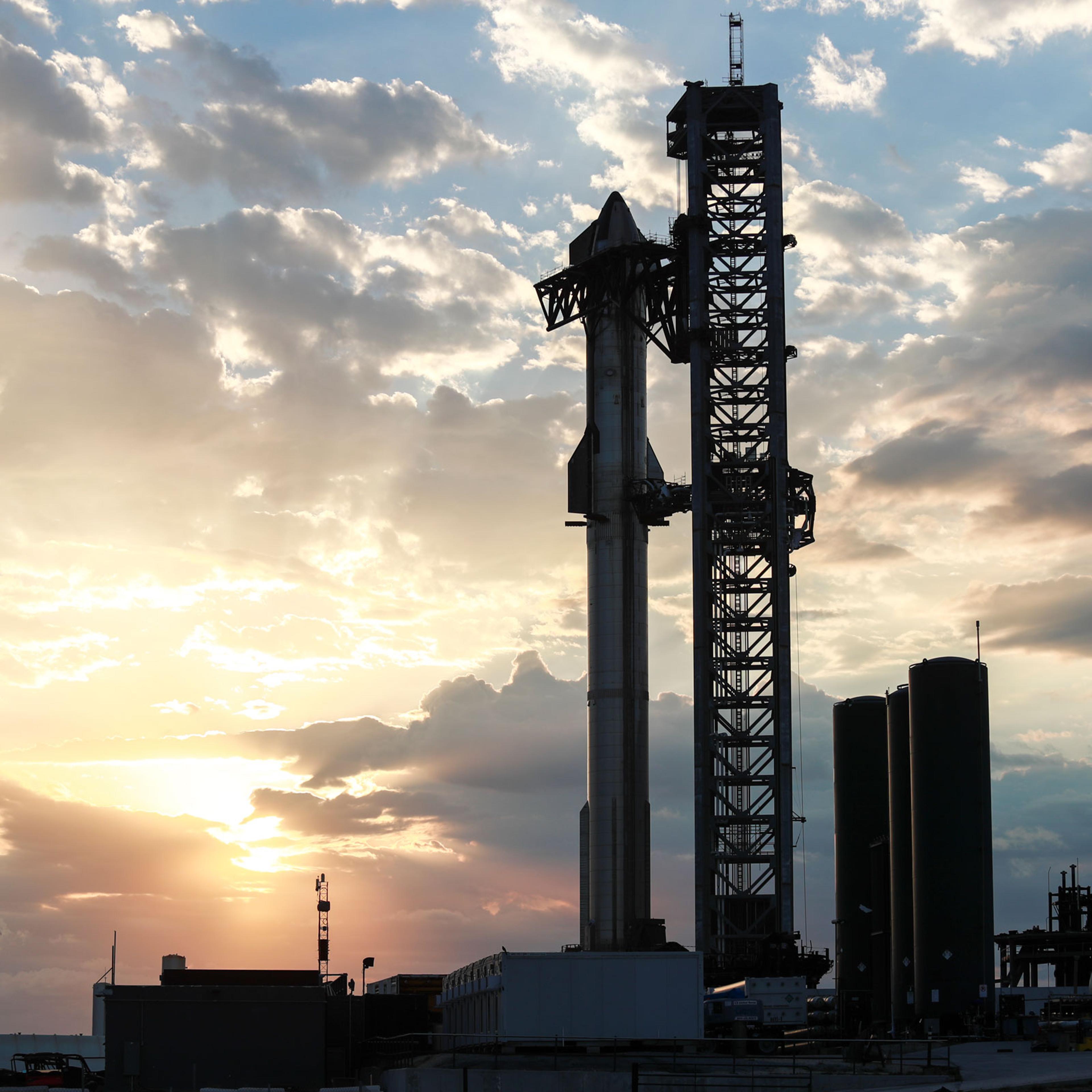 The orbital class Starship prototype stands fully stacked against the sunrise on Boca Chica Beach