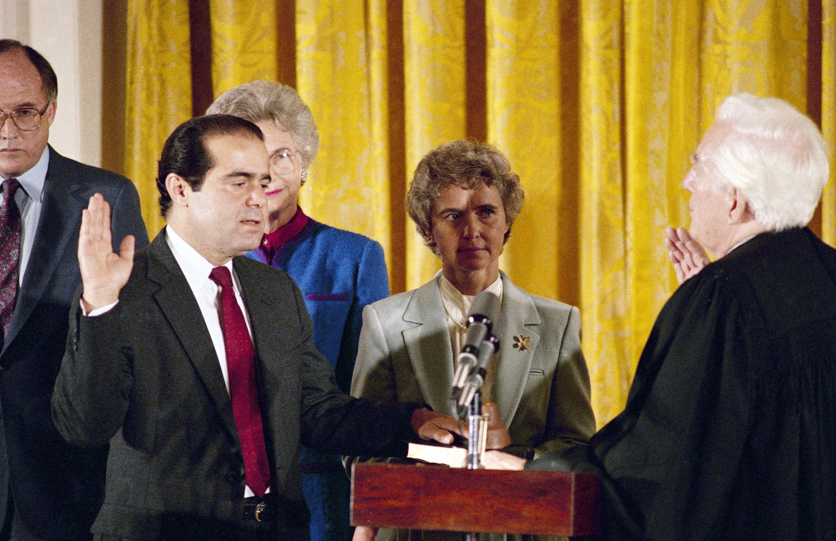 In this Sept. 26, 1986 file photo, retiring Chief Justice Warren Burger, right, administers an oath to Associate Justice Antonin Scalia, as Scalia's wife, Maureen, holds the bible during ceremonies in the East Room of White House, Washington.