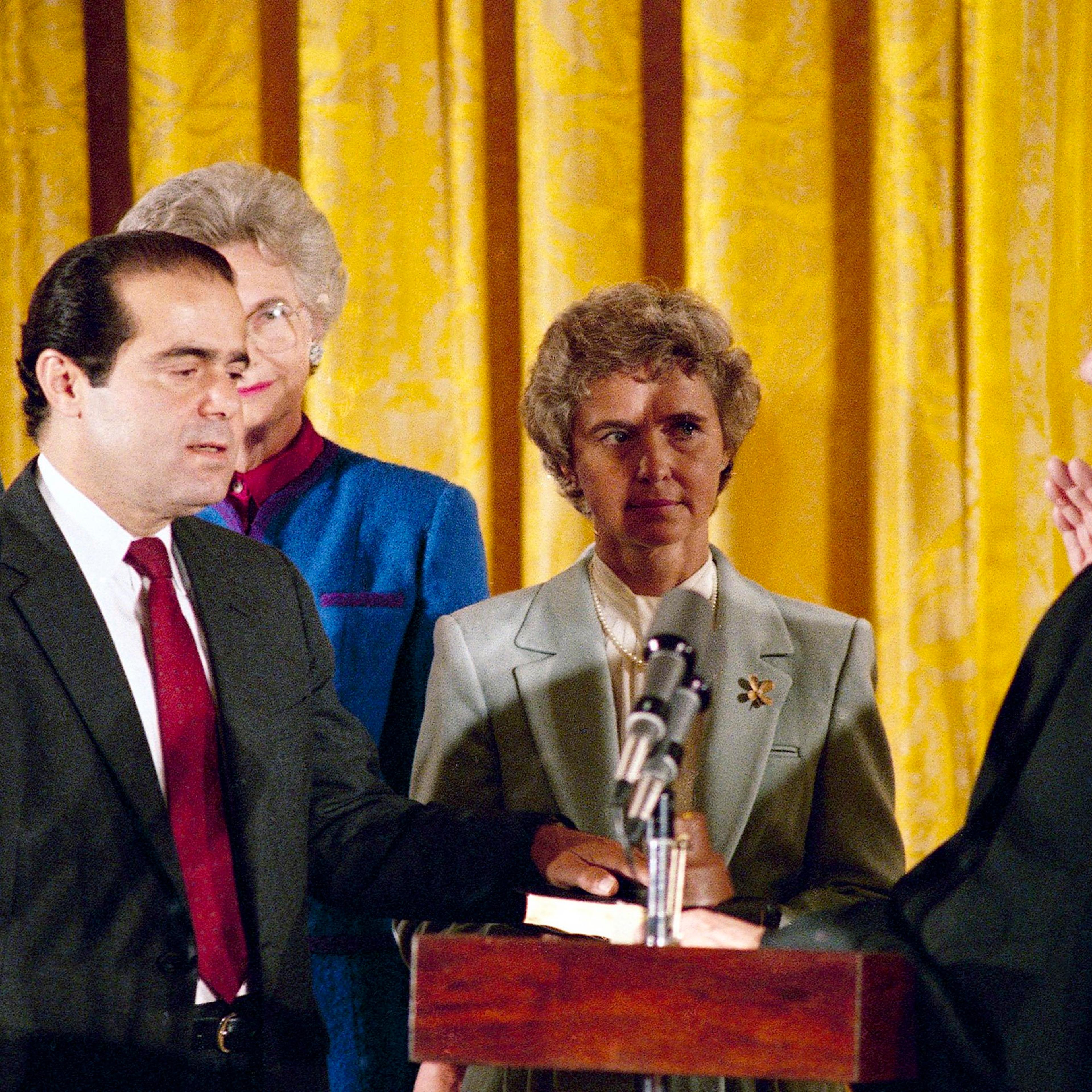 In this Sept. 26, 1986 file photo, retiring Chief Justice Warren Burger, right, administers an oath to Associate Justice Antonin Scalia, as Scalia's wife, Maureen, holds the bible during ceremonies in the East Room of White House, Washington.