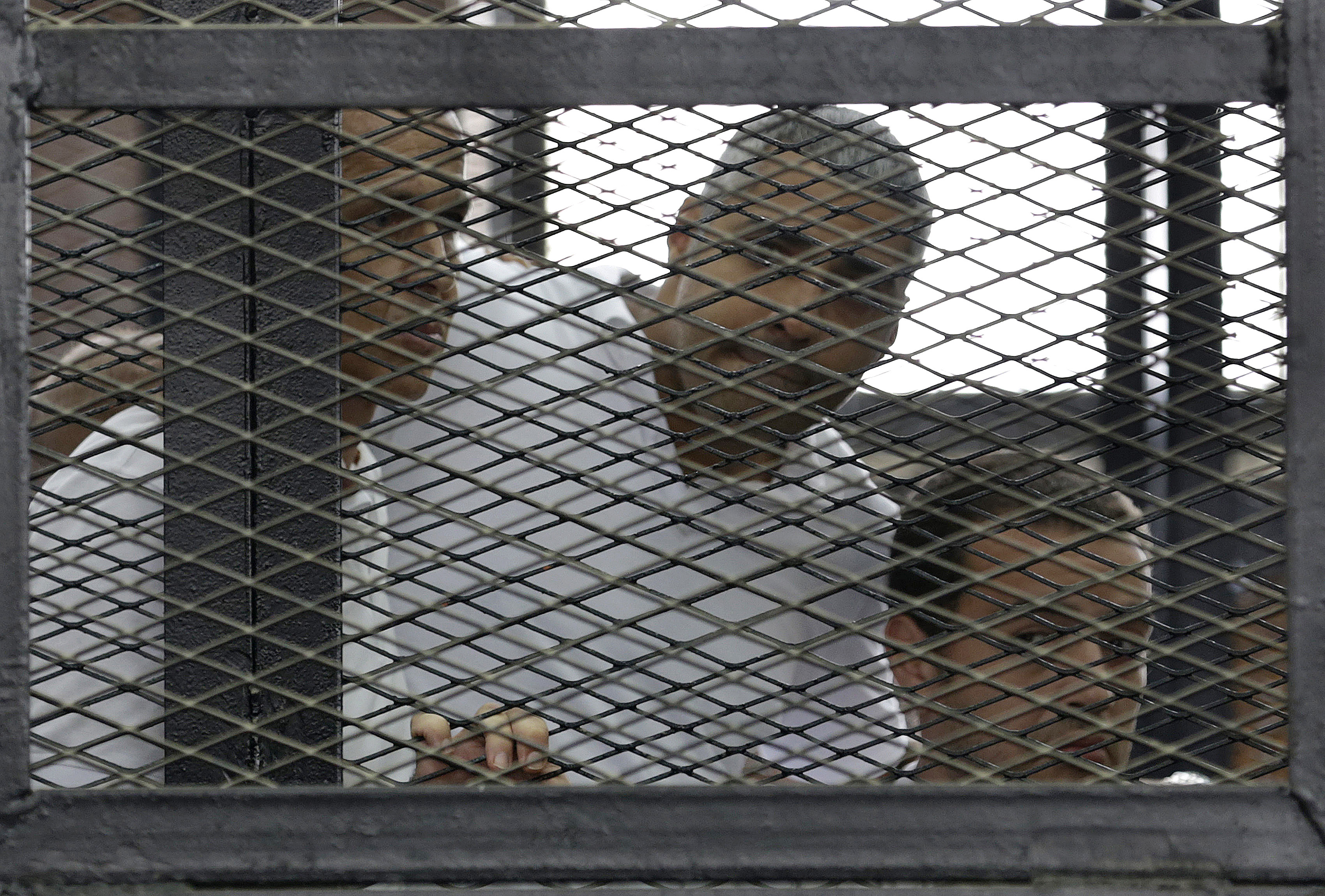 Peter Greste, Mohamed Fahmy and Baher Mohamed listen to the ruling at a court in Cairo