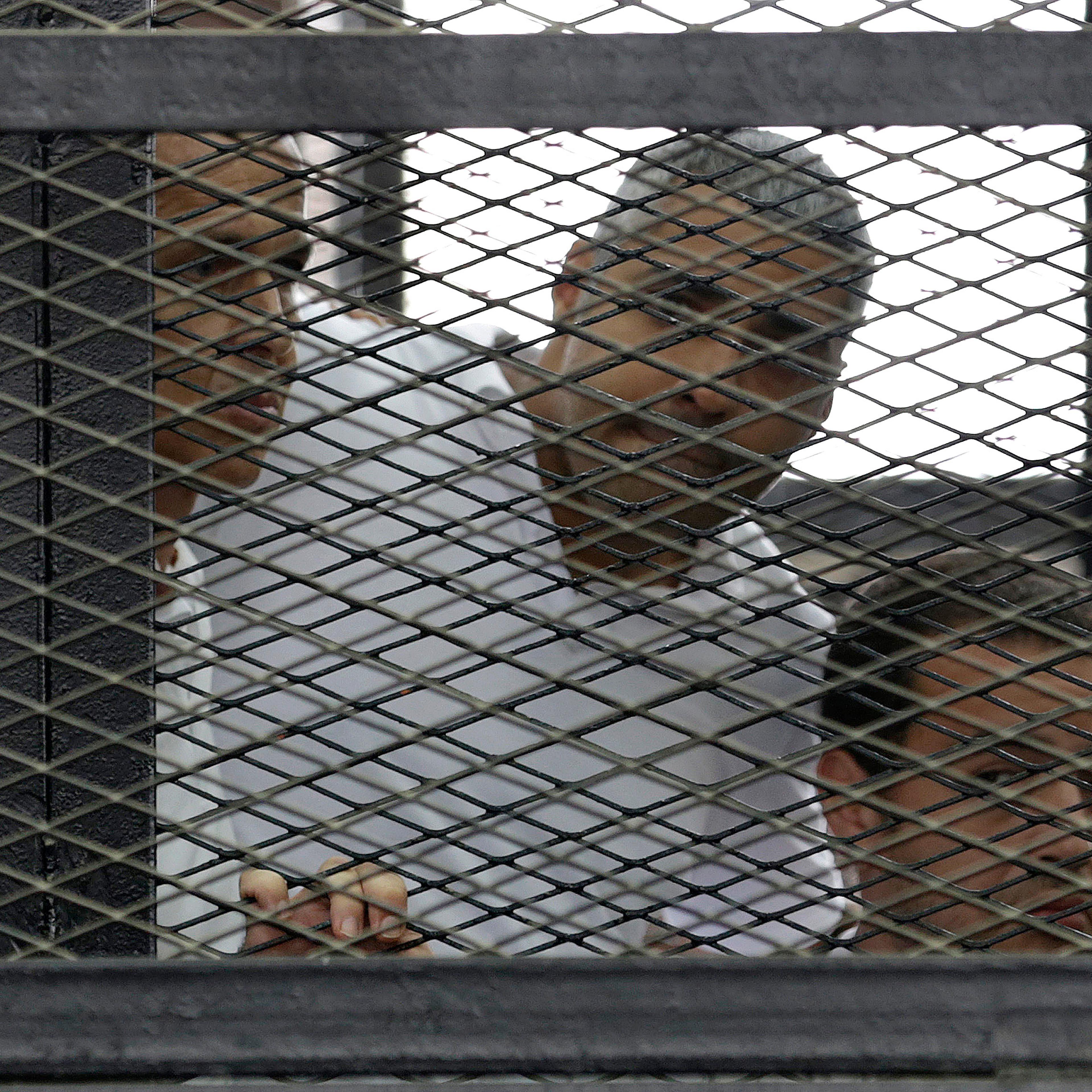 Peter Greste, Mohamed Fahmy and Baher Mohamed listen to the ruling at a court in Cairo