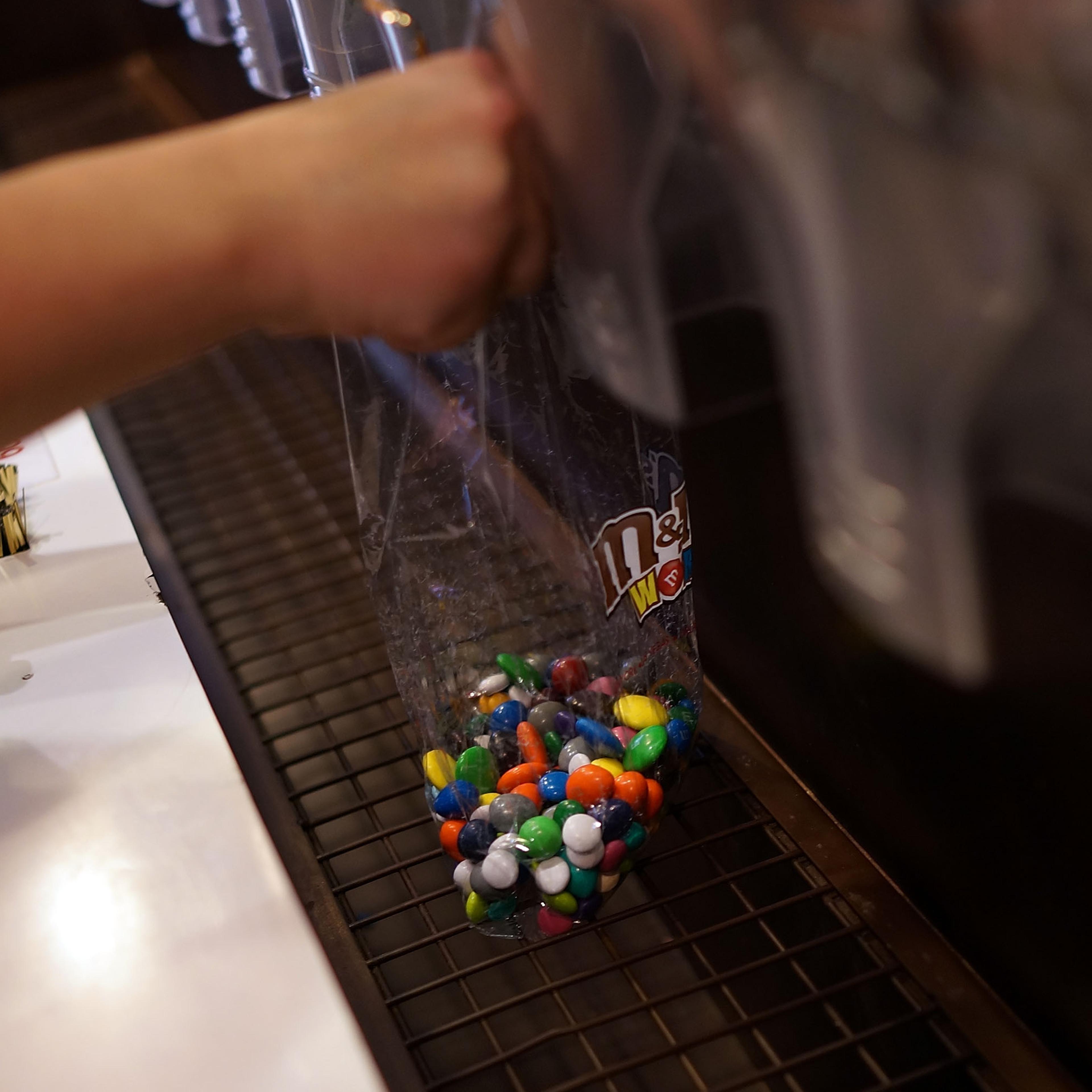 People fill up bags of M&M's at the M&M store in Times Square in New York City on July 24, 2014.