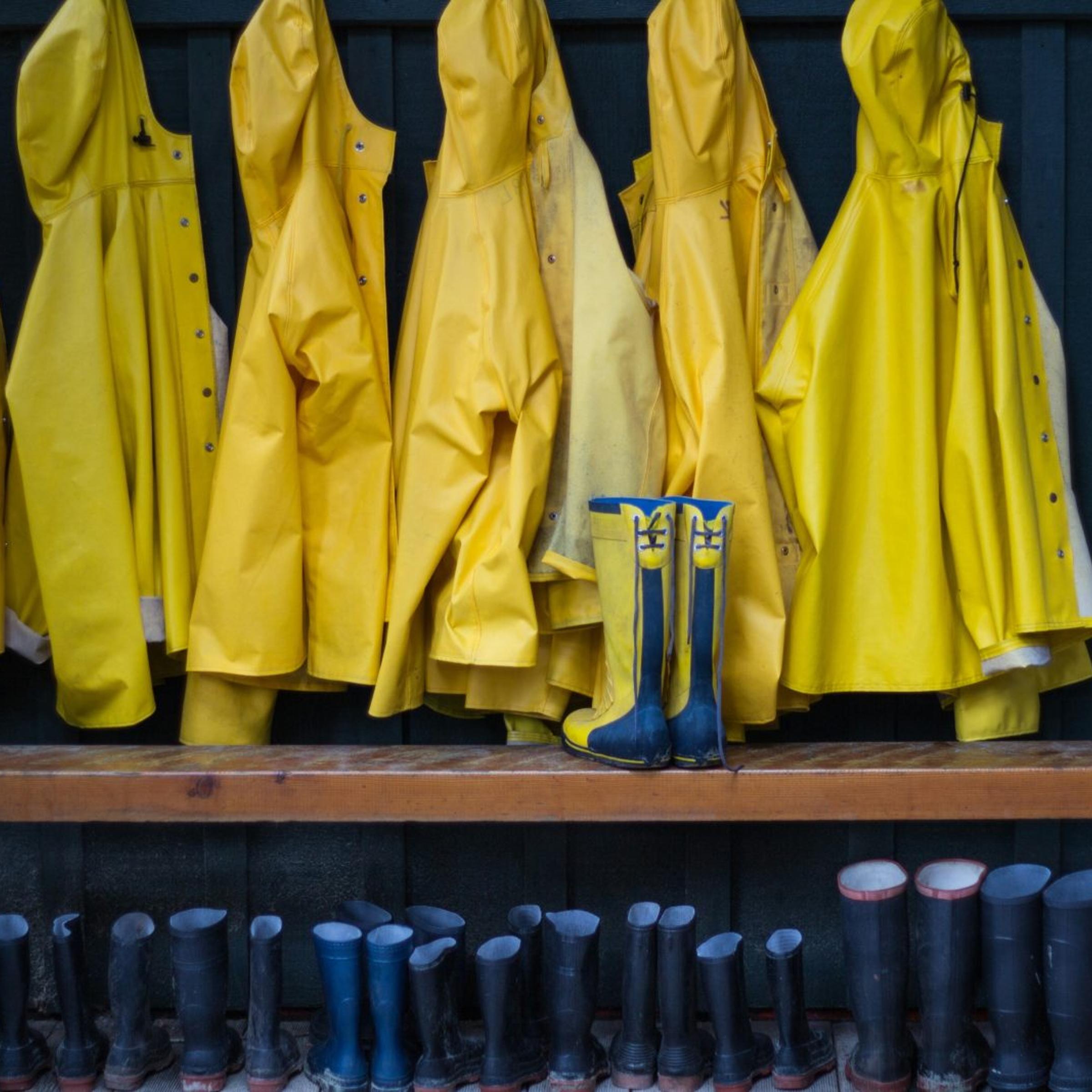 Yellow Raincoats And Rubber Boots Arranged Outdoors