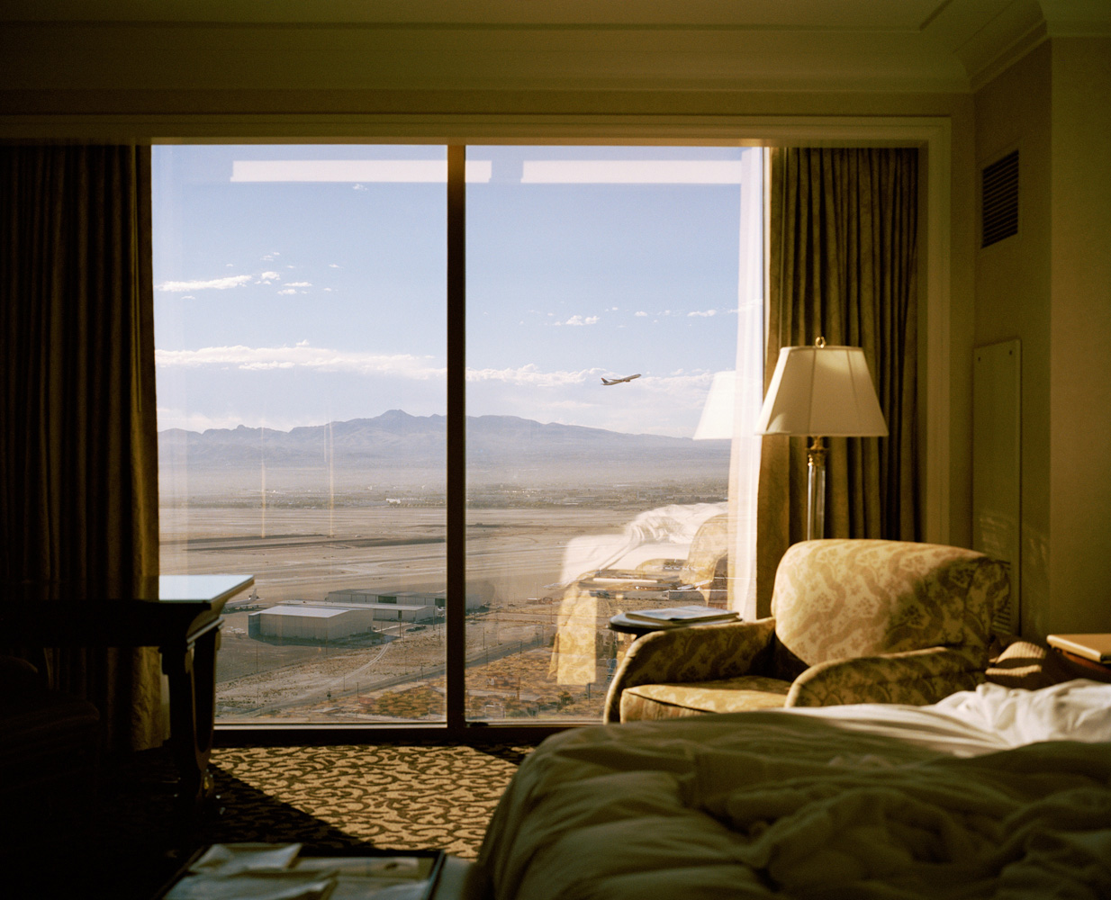 <b>Plane, Las Vegas, Nevada, 2007</b><br />
</br><i>Curator Andy Adams of Flak Photo asked each photographer 'Why did you photograph this place?'</i></br><br />
</br>"This image was taken in Las Vegas. It was one of those images that I had to take; it really jumped out at me. I was away working staying in this hotel, I woke up early the morning I was due to leave and came out of the bathroom where this scene was all laid out. I took two photographs from the same position, one with and one without the plane. For me it says so much about our relationship with the landscape and how we as humans stake our claim on the world and alter it for our own gains. Vegas is the ultimate artificial landscape and I like this alternative view, more intimate, the other side of the facade."
