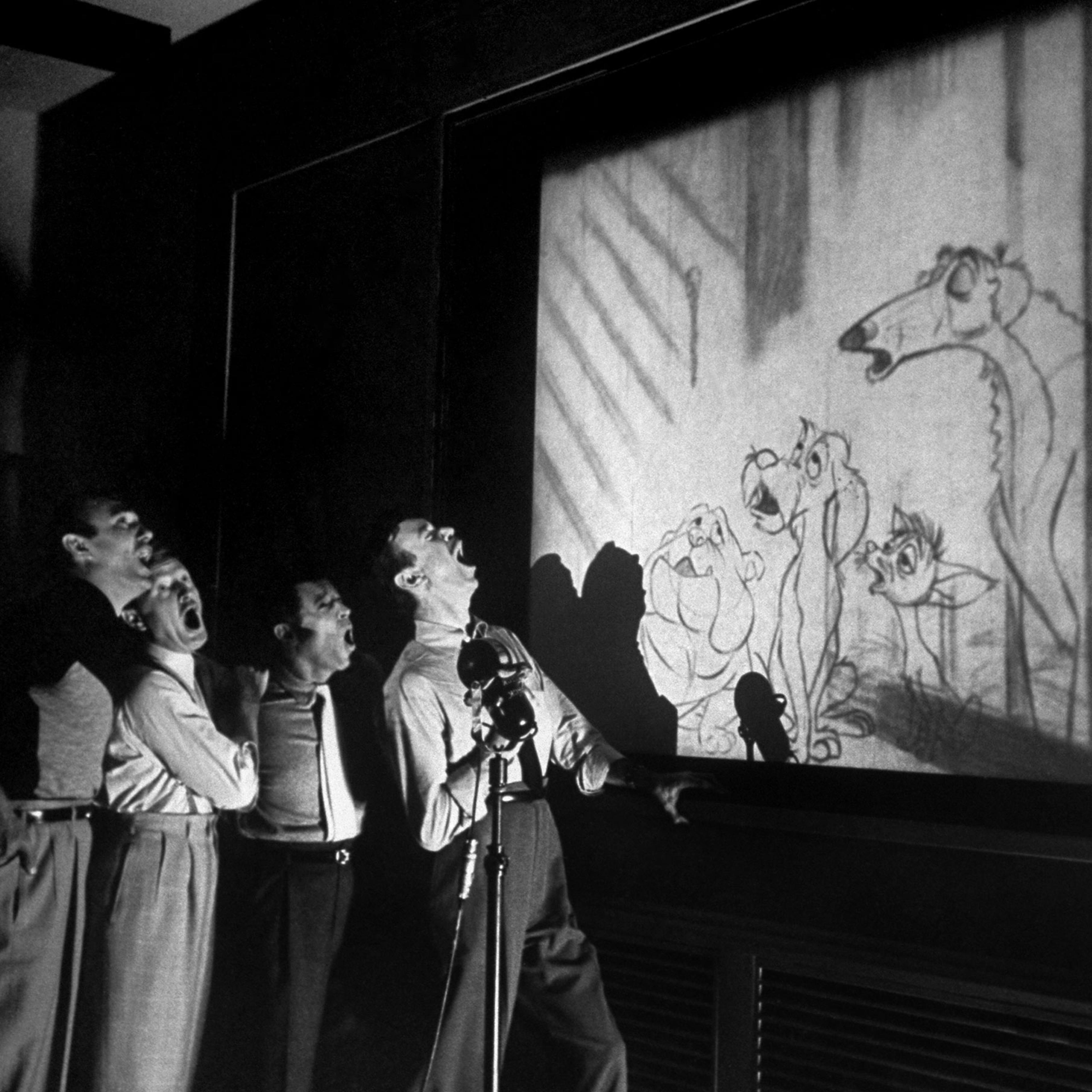 Quartet known as The Mello-Men bays in harmony before screen showing four canine characters whose voices they represent in the forthcoming Disney feature cartoon, The Lady and The Tramp.