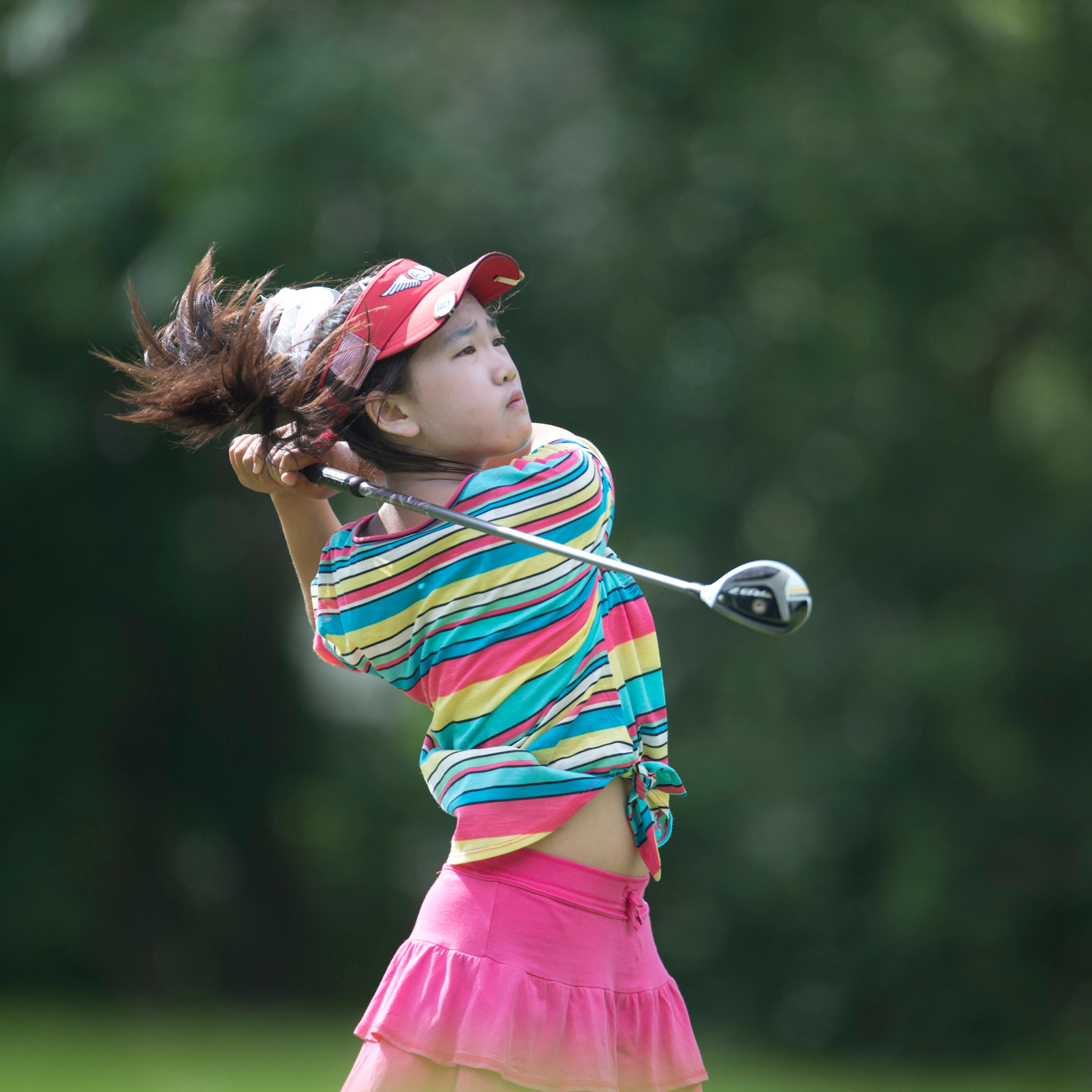 This photo provided by the USGA shows Lucy Li hitting a tee shot on the sixth hole during the first round of the 2013 U.S. Women's Public Links golf event in Norman, Okla, June 19, 2013.