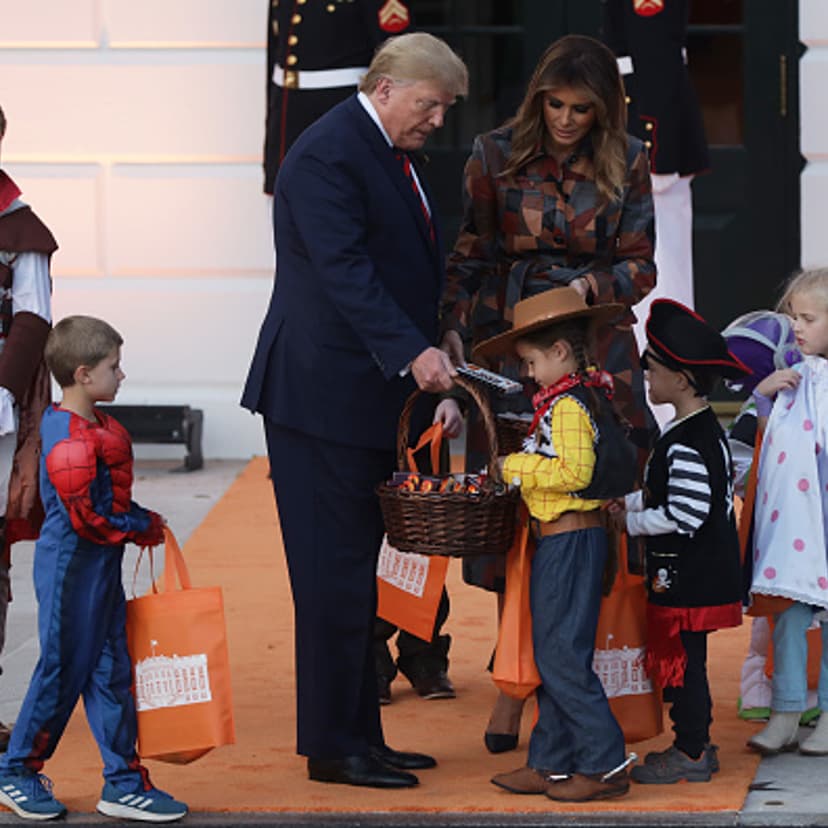 U.S. President Donald Trump and first lady Melania Trump hand out candy to children as they trick-or-treat during a Halloween at the White House event at the South Portico of the White House in Washington, DC on October 28, 2019.