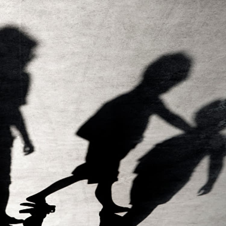 Blurry shadows of three boys friends walking together