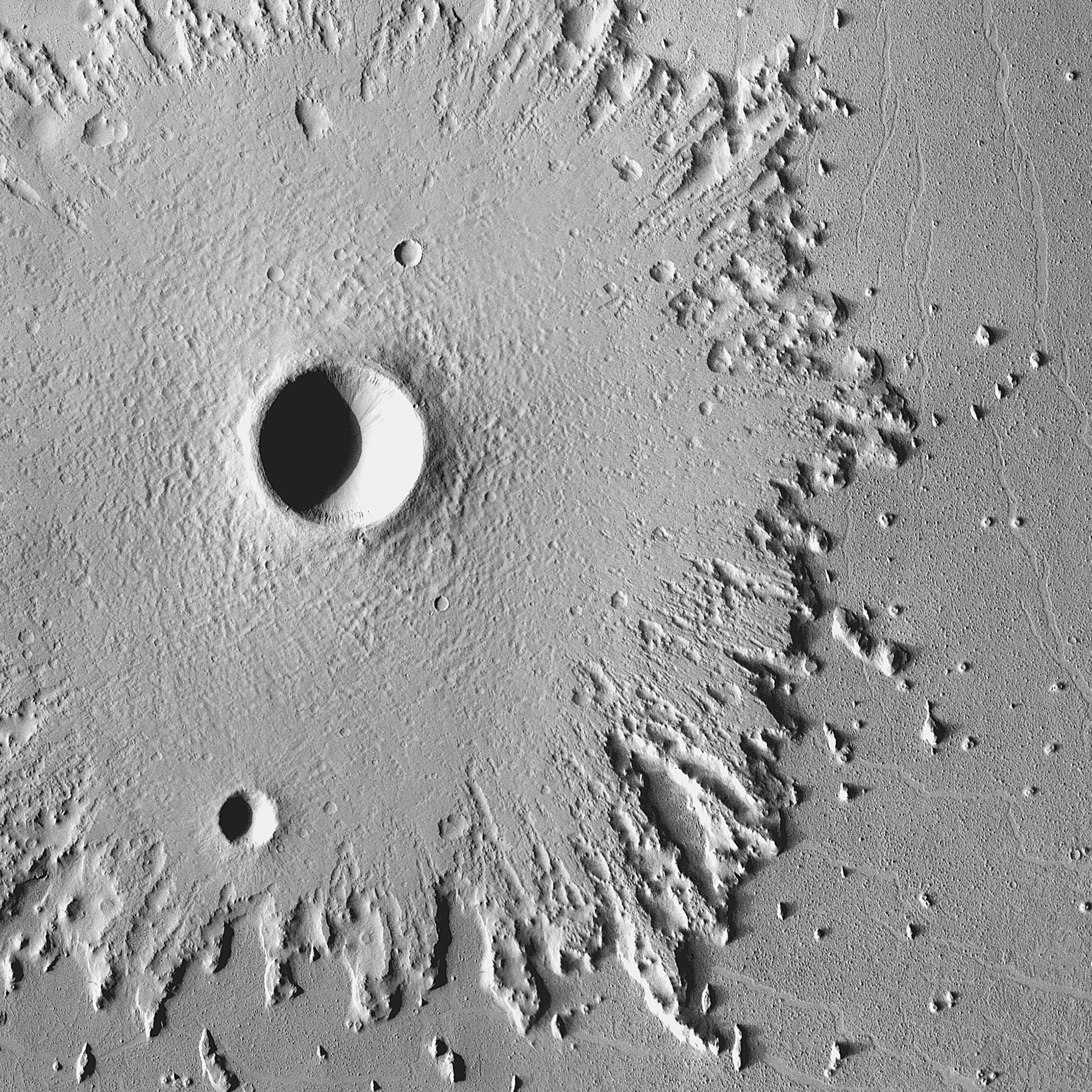 Radical Erosion: The wide, circular blanket of ejected debris surrounding this crater has become greatly eroded by the wind, which has stripped its surface features. This images was acquired between May 2003 and April 2006 by the Thermal Emission Imaging