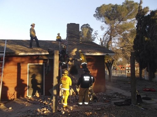 Local fire and sheriff personnel respond to a home after a suspected burglar got stuck in the chimney and died in Fresno, Calif. on Nov. 29, 2015.