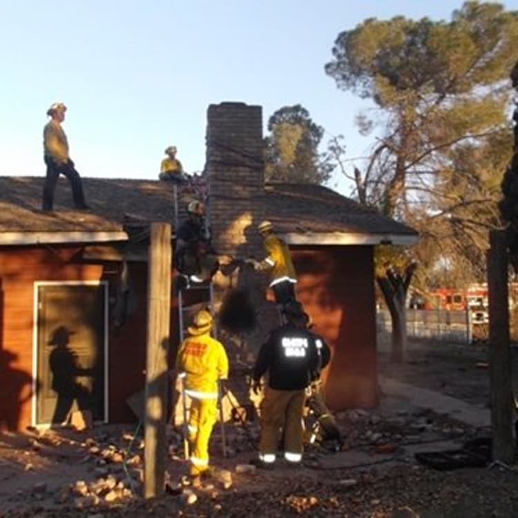 Local fire and sheriff personnel respond to a home after a suspected burglar got stuck in the chimney and died in Fresno, Calif. on Nov. 29, 2015.