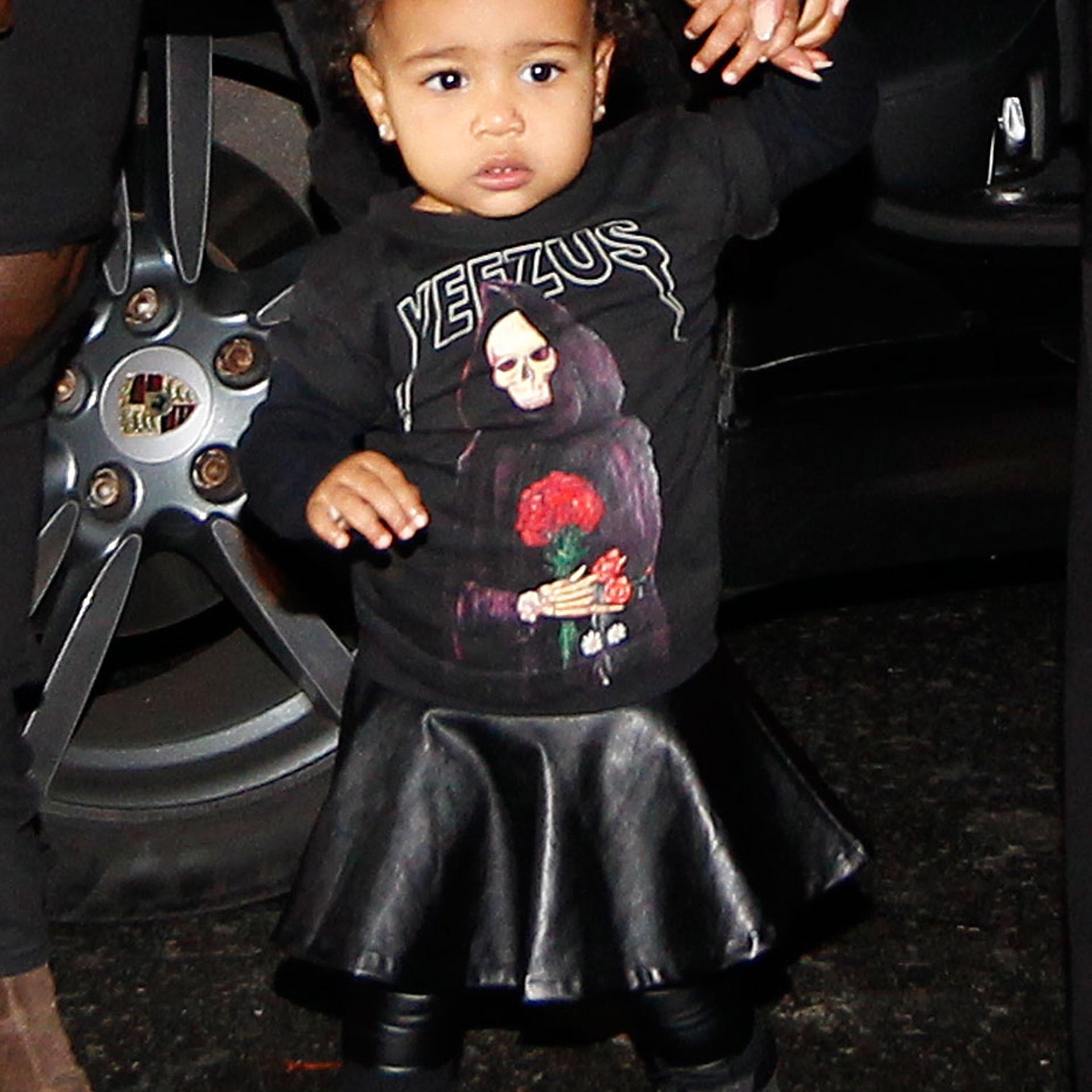 Kanye West, Kim Kardashian and their daughter North West walk to the Balenciaga Womenswear Spring/Summer 2015