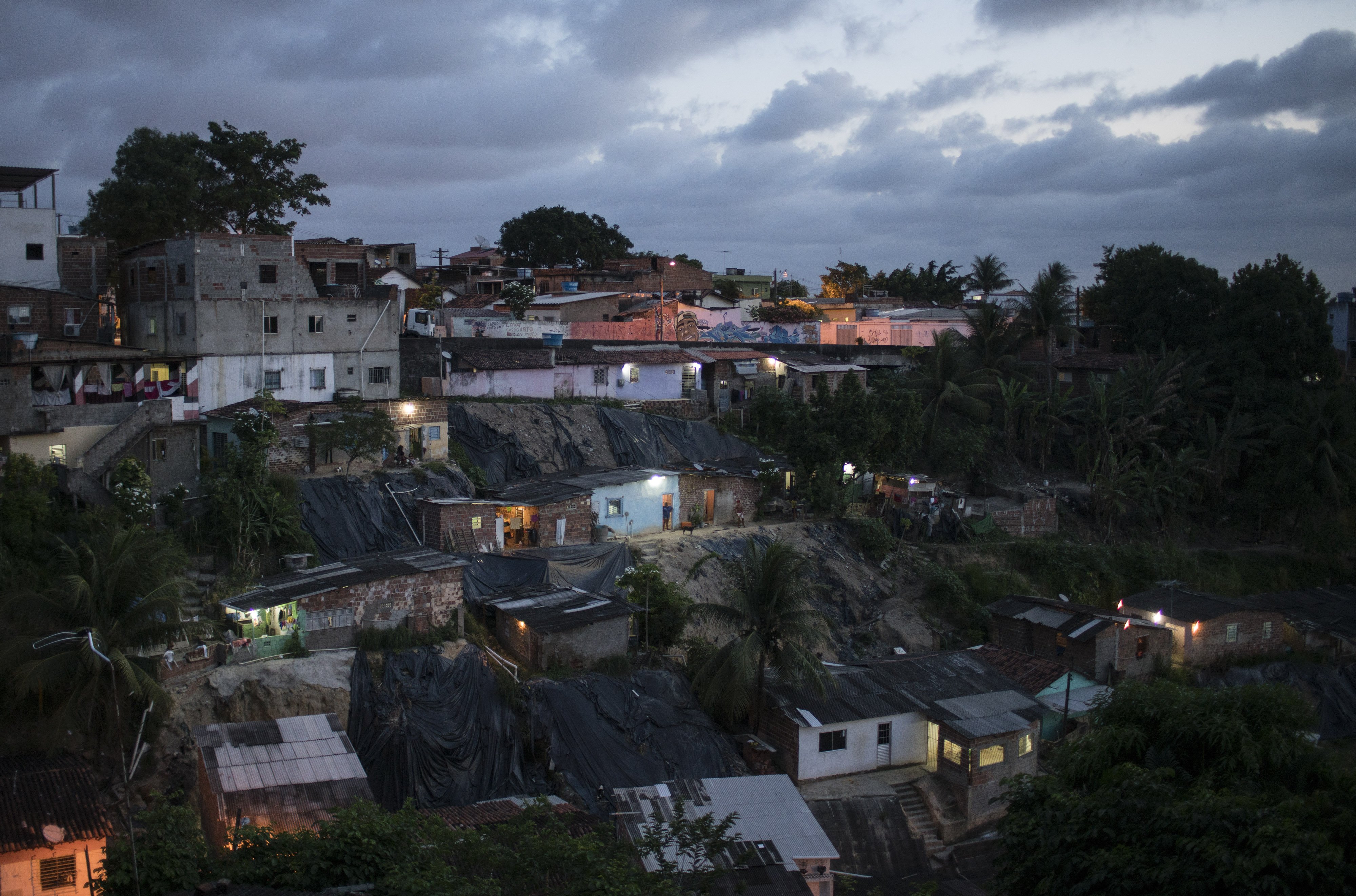 Homes are lit as the sun goes down in Ibura, one of the neighborhoods with the highest numbers of suspected cases of children born with microcephaly in Recife, Brazil, Jan. 27, 2016.