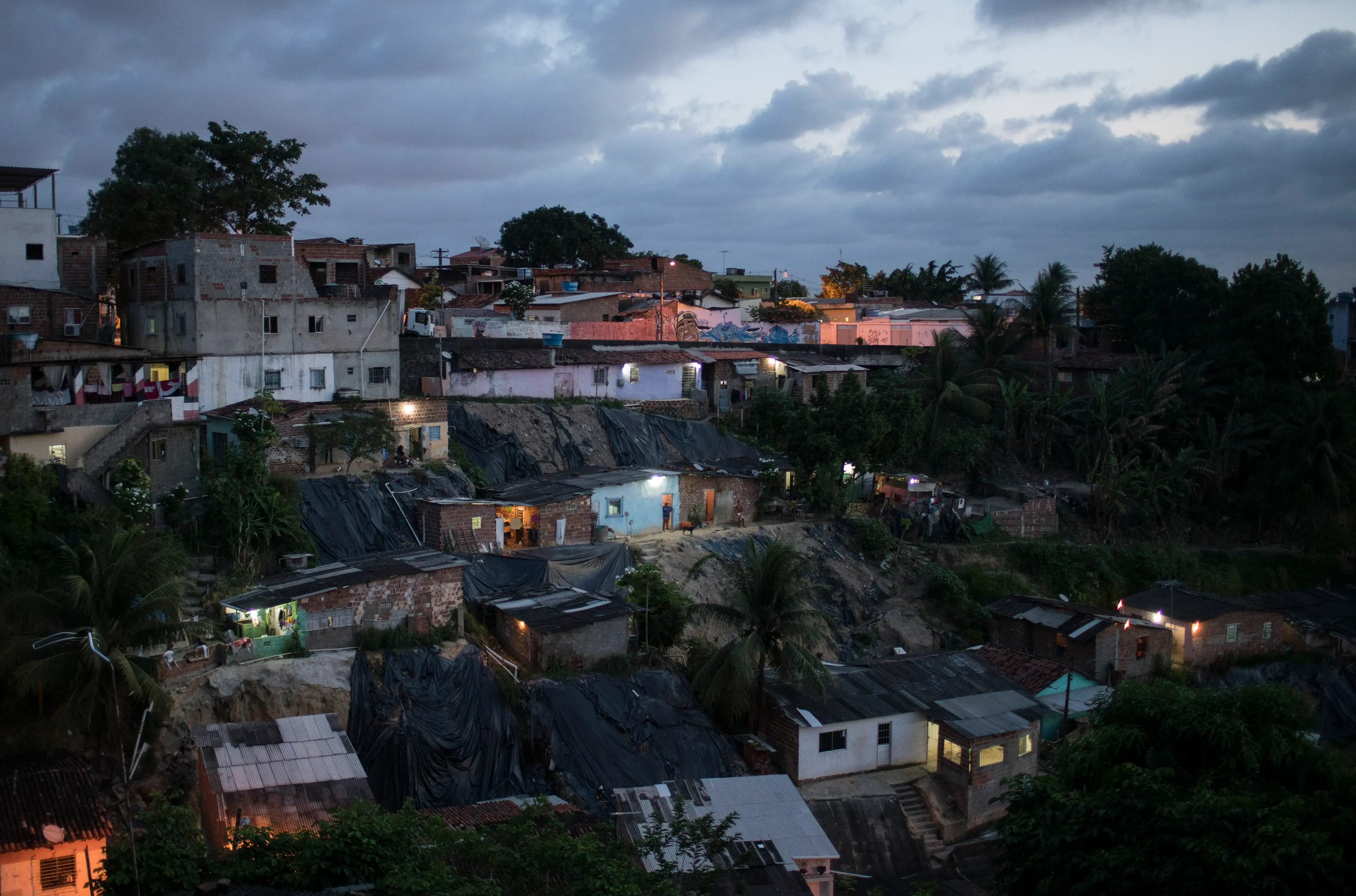Homes are lit as the sun goes down in Ibura, one of the neighborhoods with the highest numbers of suspected cases of children born with microcephaly in Recife, Brazil, Jan. 27, 2016.