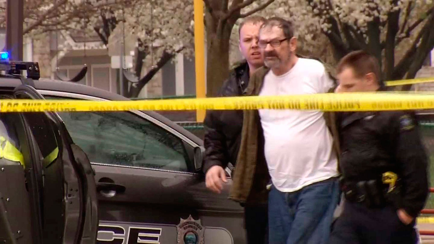 Frazier Glenn Cross, 73, of Aurora, Missouri, is led to a police car after his arrest following shooting incidents which killed three people at two Jewish centers on Sunday in Overland Park, south of Kansas City, Kansas in a still image from video April 
