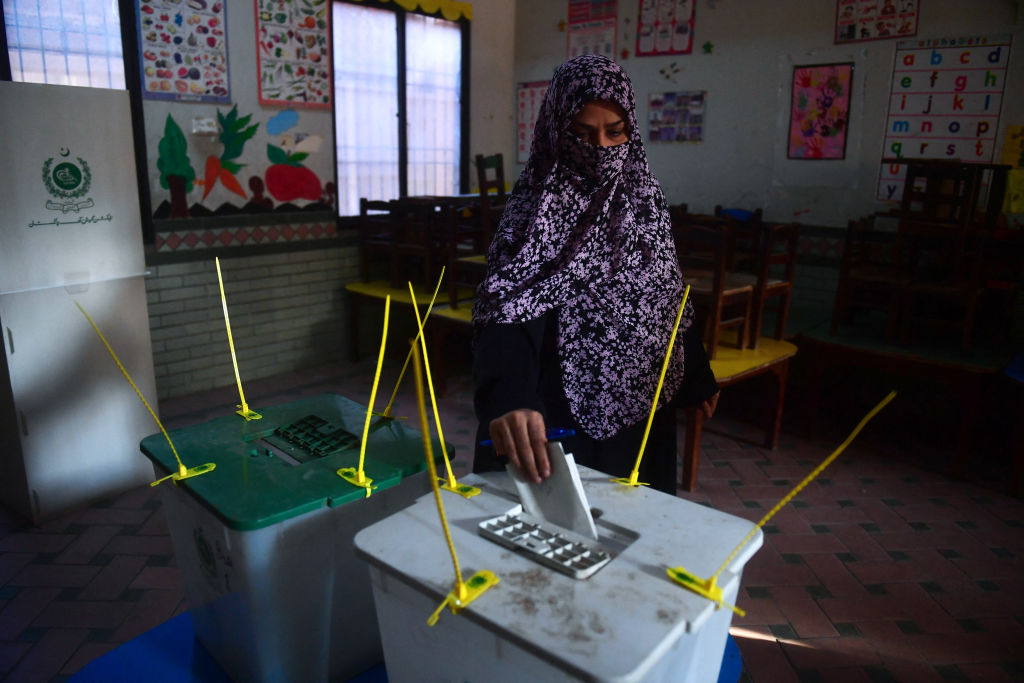 A woman casts her vote at a polling station during Pakistan's national elections in Karachi on Feb. 8, 2024.