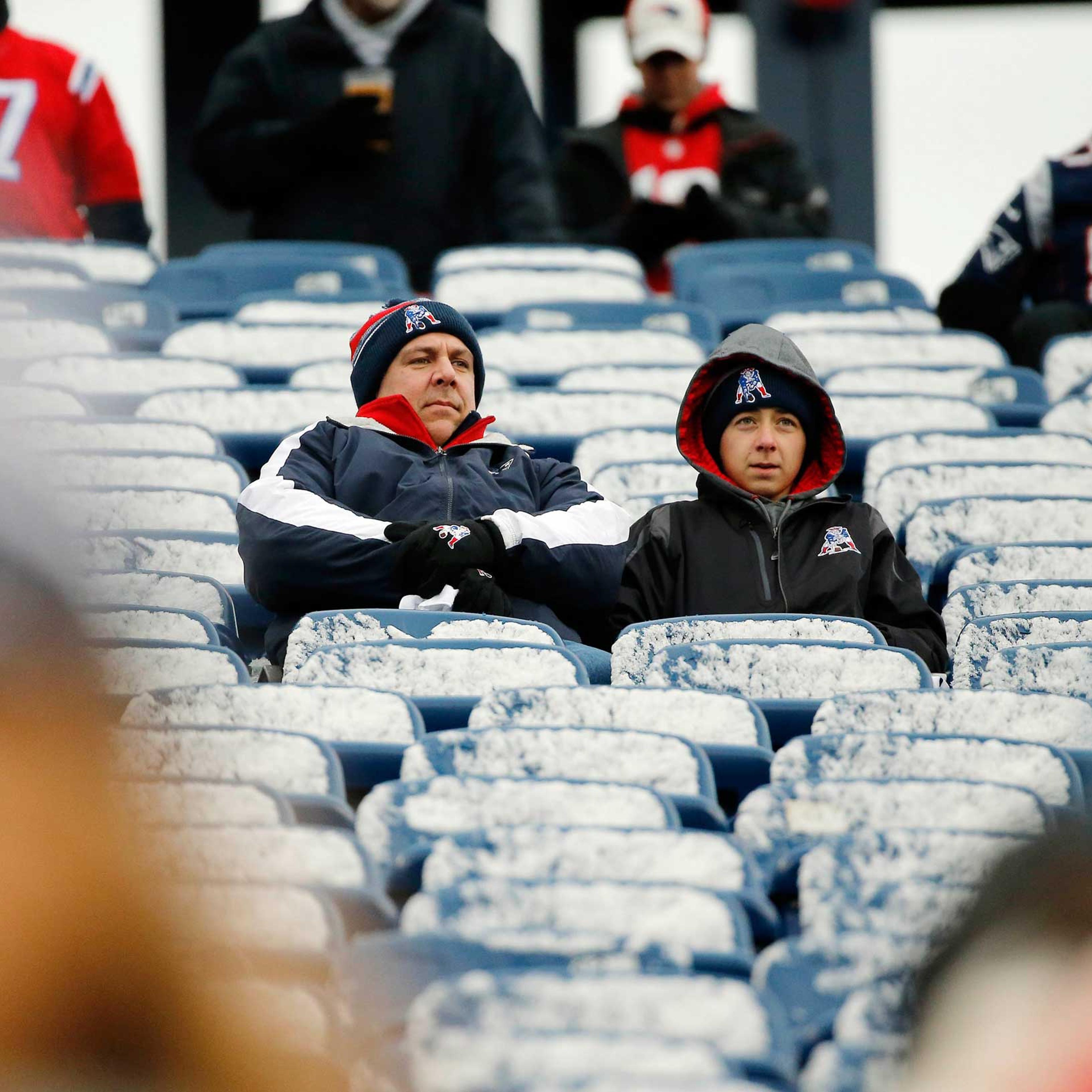 New England Patriots fans sit in seats coated by a light morning snow before an NFL football game between the Patriots and the Denver Broncos on Nov. 2, 2014, at Gillette Stadium in Foxborough, Mass.