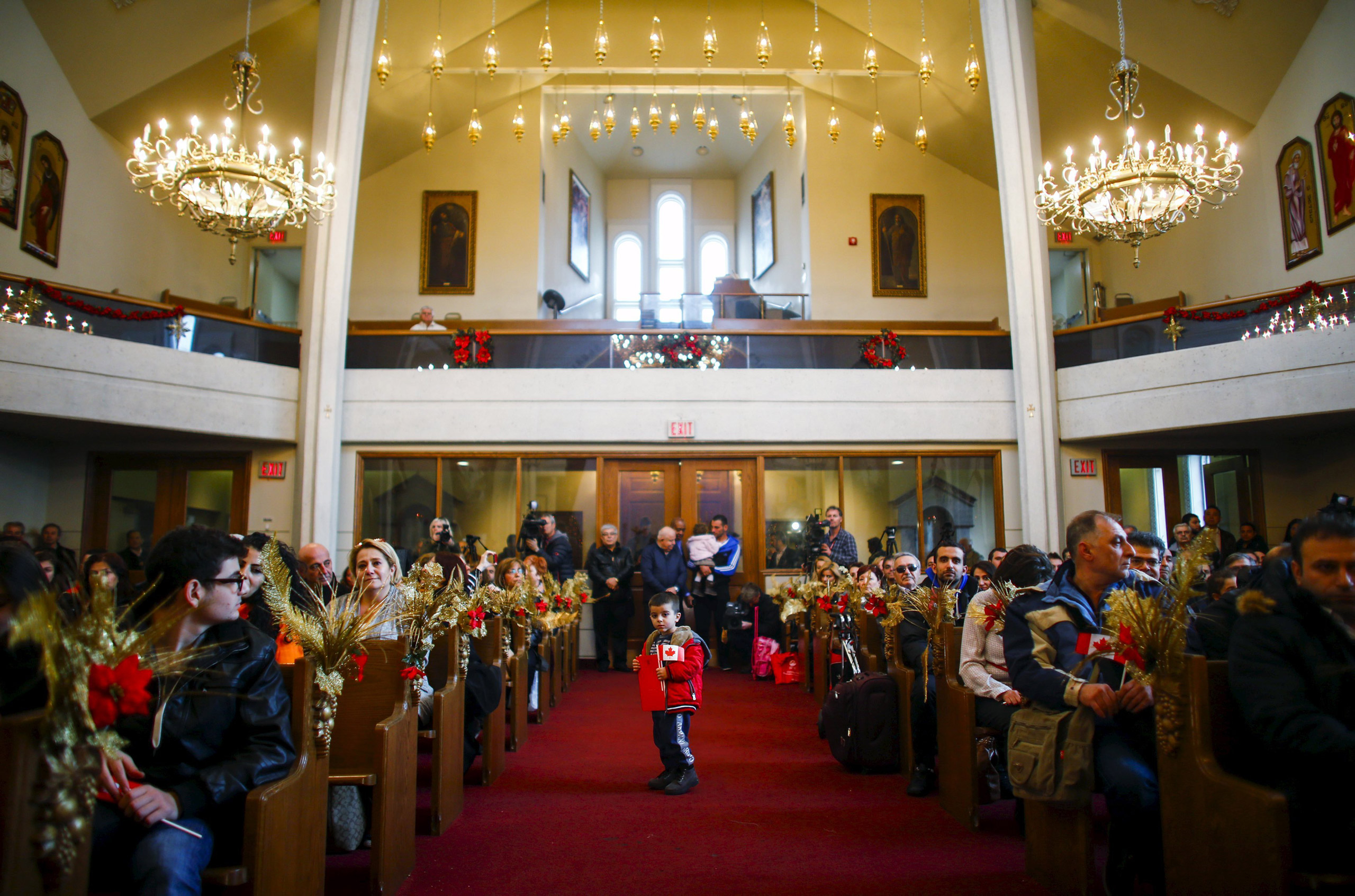 REFILE - CORRECTING CITY Syrian refugee Levon Kourken, 4, stands on an aisle during a welcoming service for Syrian refugees at St. Mary Armenian Apostolic Church at the Armenian Community Centre of Toronto in Toronto, December 11, 2015. REUTERS/Mark Blin
