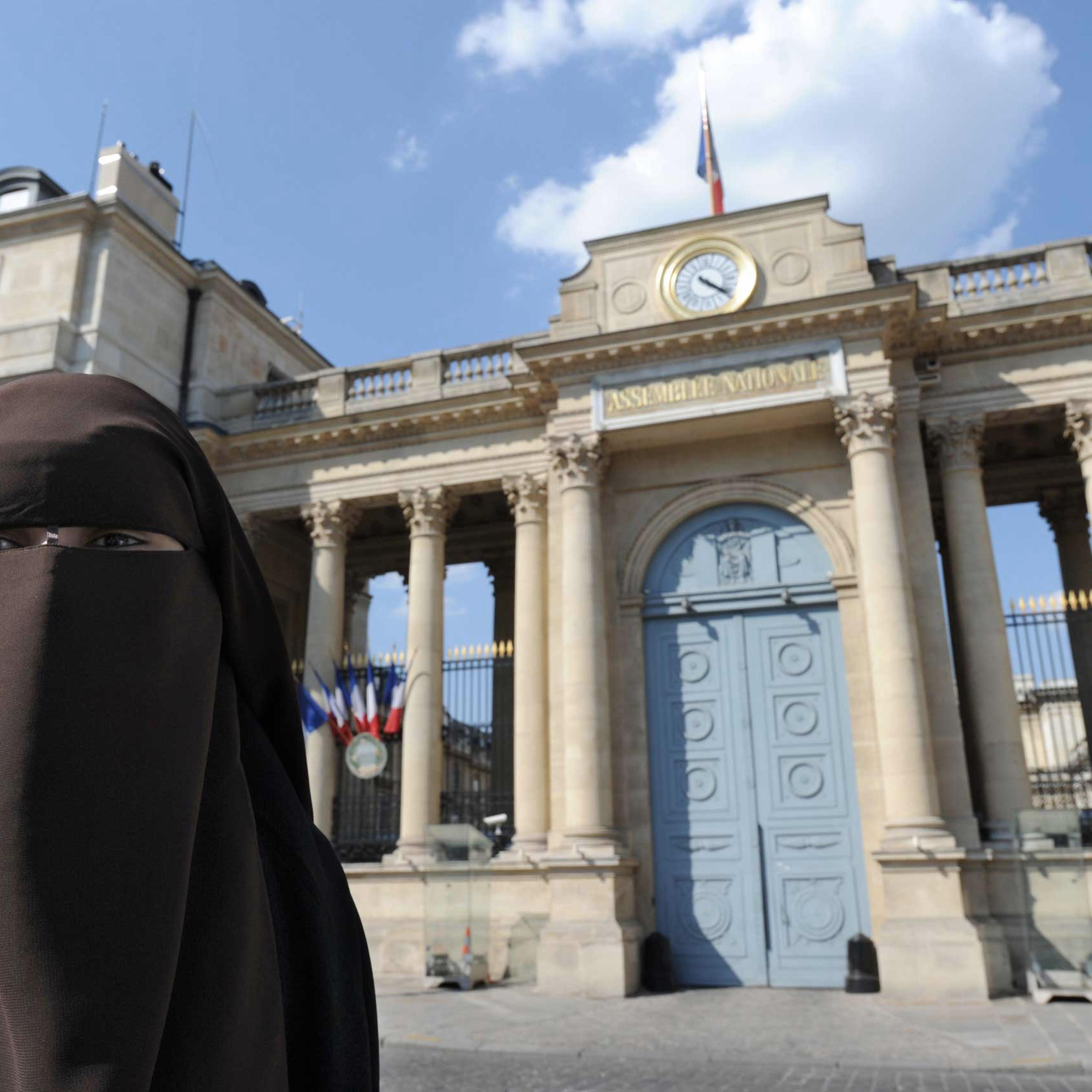 A Niqab veiled woman poses in front of the French National Assembly to protest against France's ban on wearing full-face niqab veils in public, in Paris in 2011.