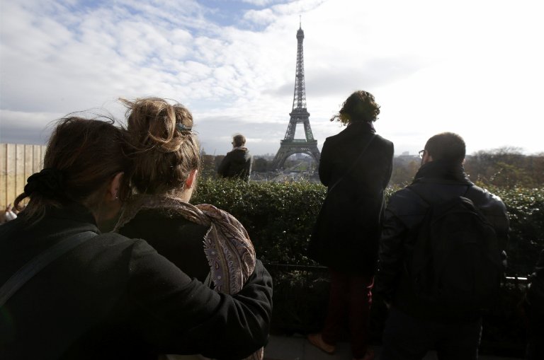 People observe a minute of silence at the Trocadero in front the Eiffel Tower to pay tribute to the victims of the series of deadly attacks on Friday in Paris