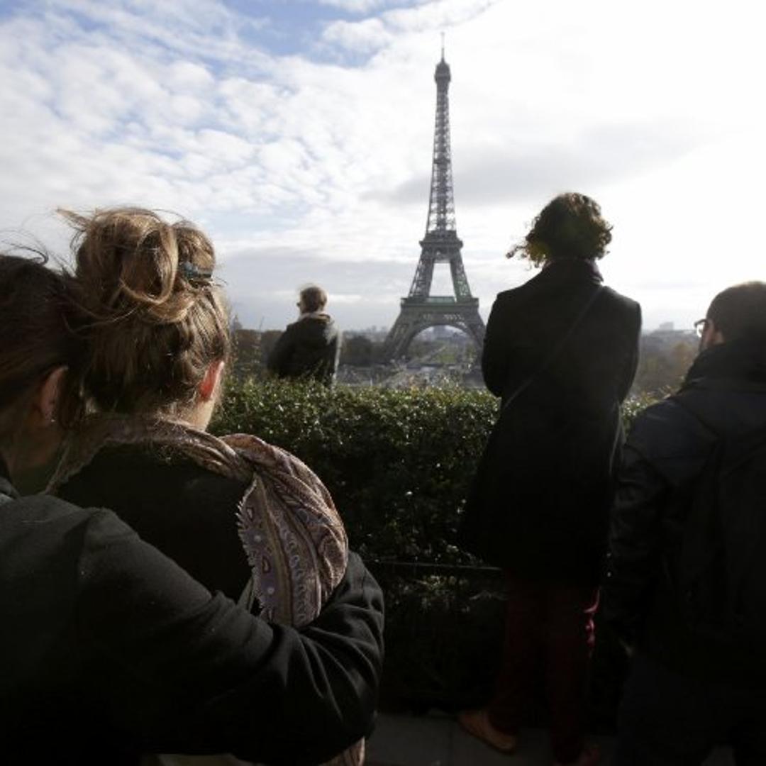 People observe a minute of silence at the Trocadero in front the Eiffel Tower to pay tribute to the victims of the series of deadly attacks on Friday in Paris