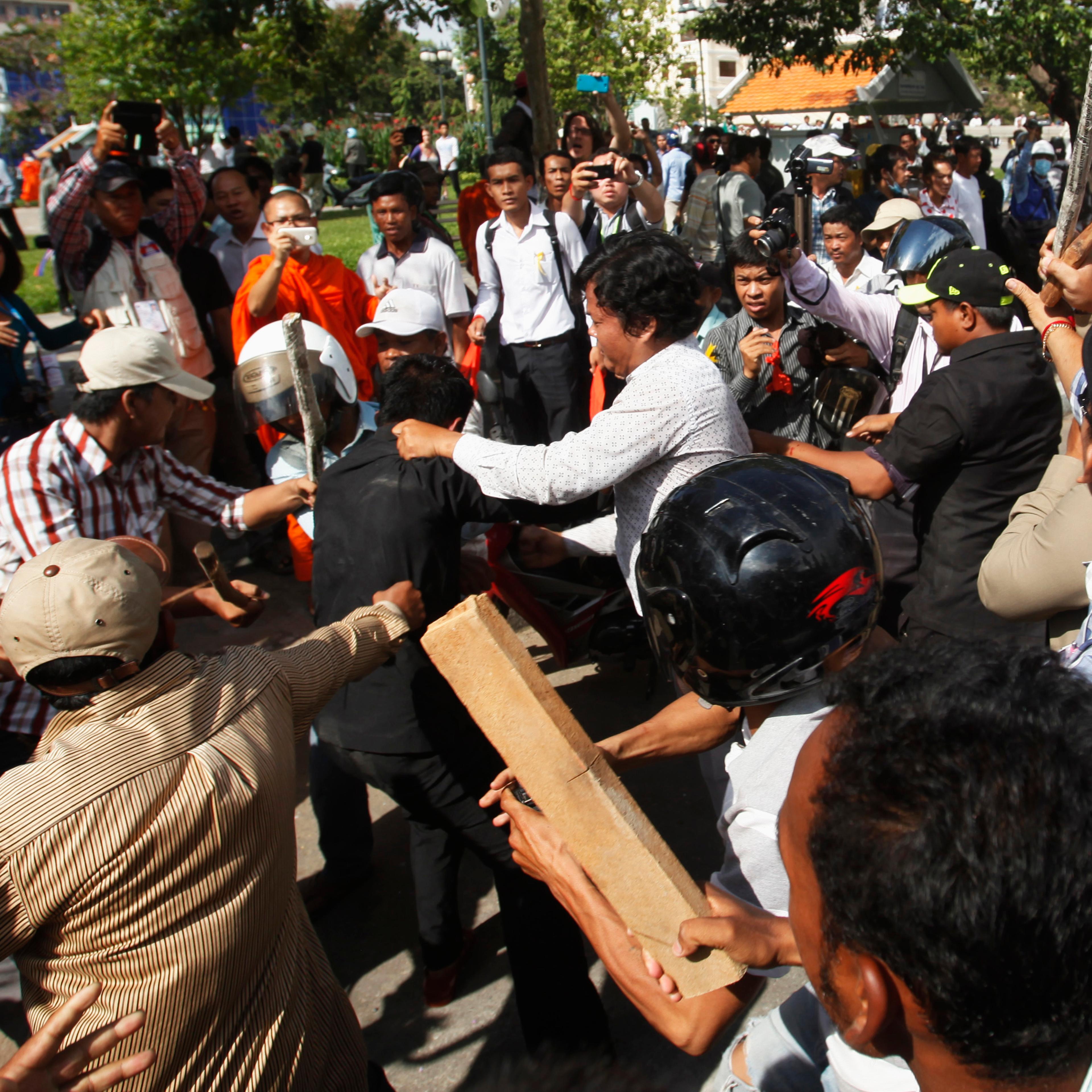 Police officers scuffle with protesters during clashes at Freedom Park in central Phnom Penh