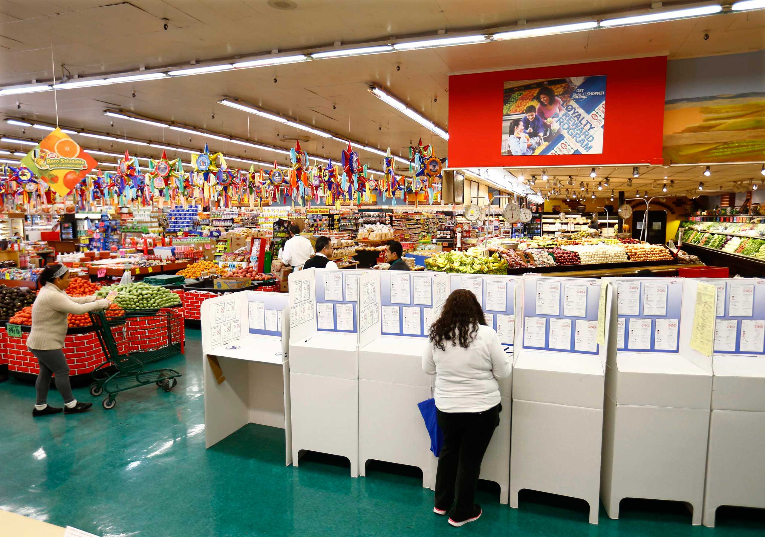 A woman votes at a polling station in a local grocery store during U.S. midterm elections, in National City