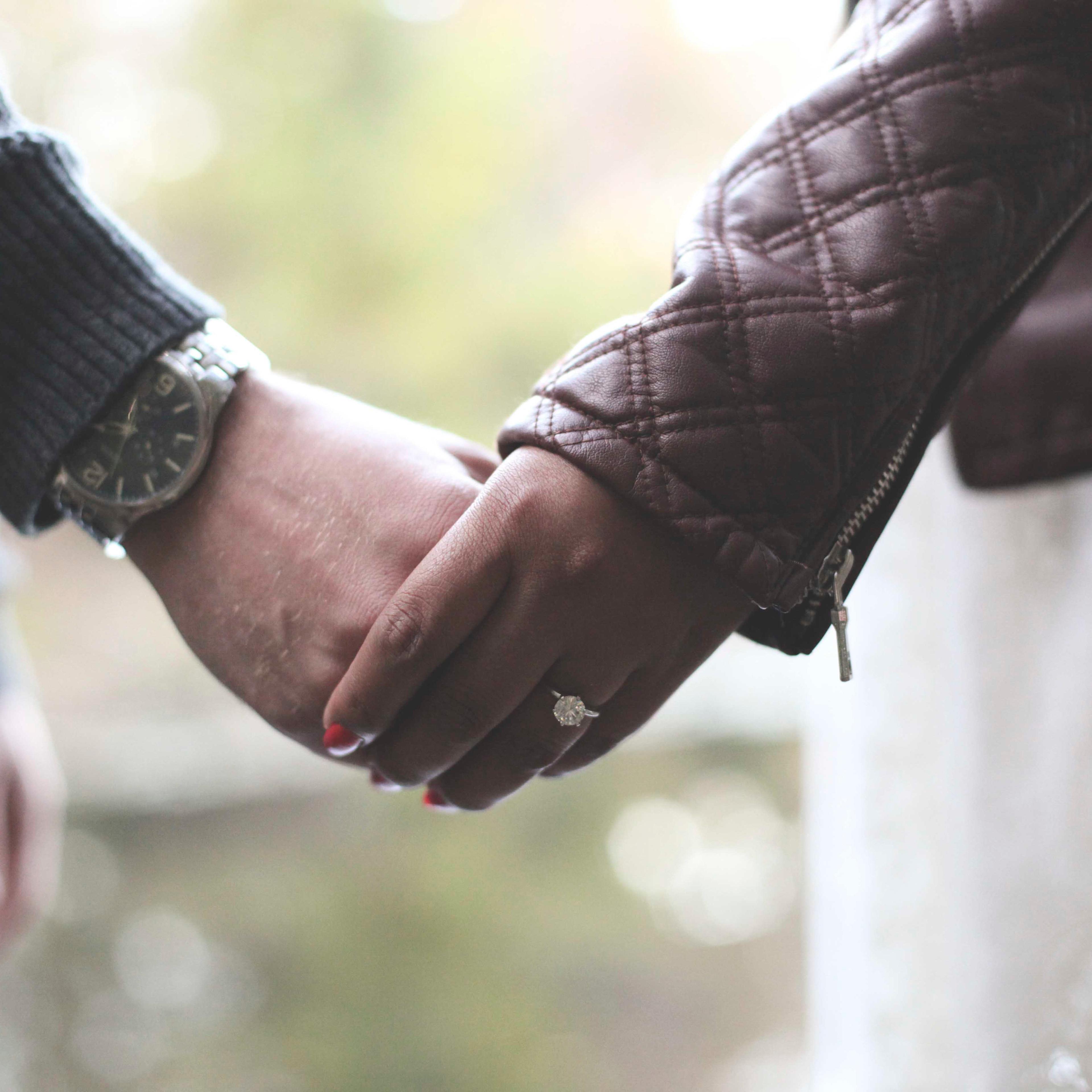 Close up of engaged couple holding hands