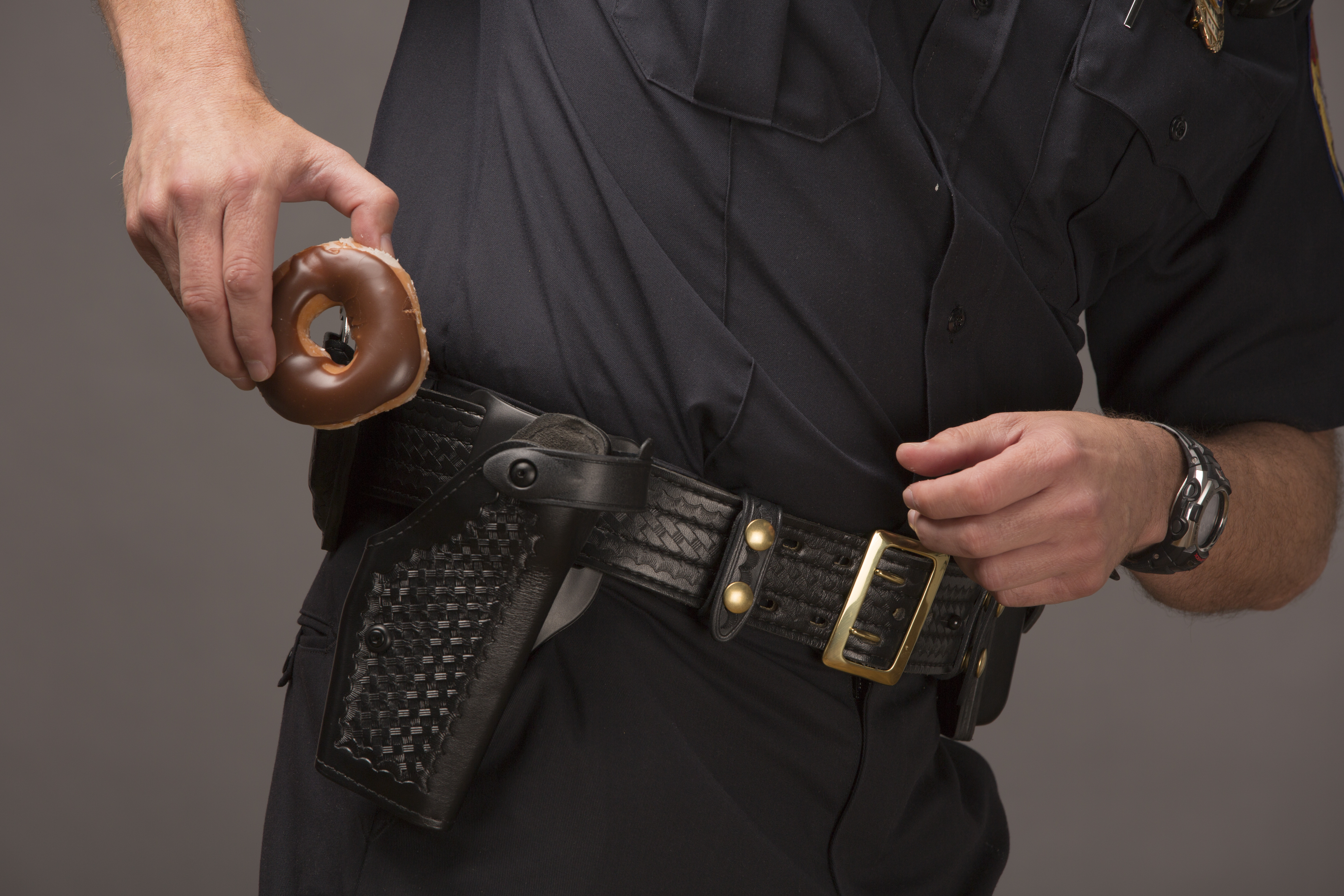 Policeman Drawing A Doughnut From Holster