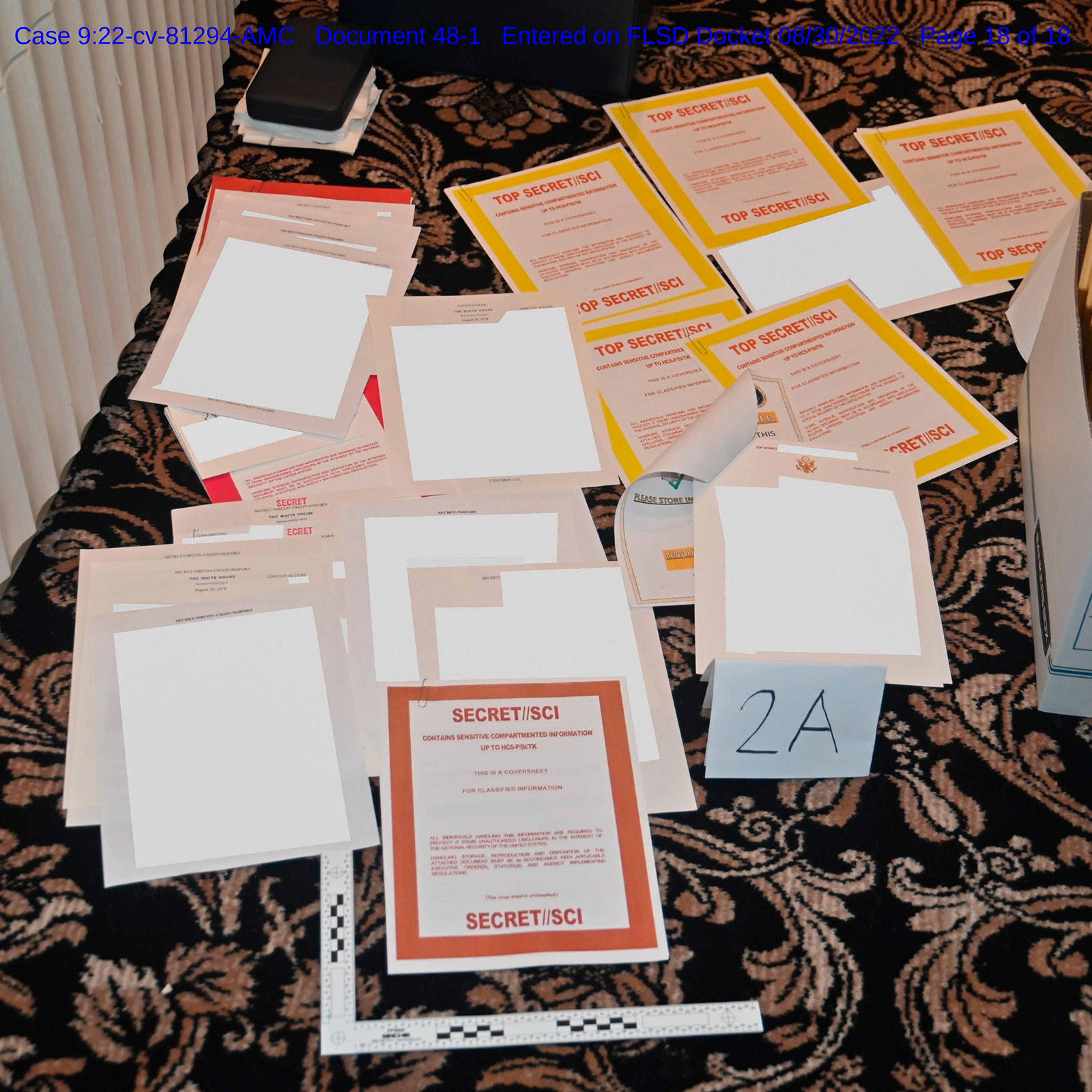 This image contained in a court filing by the Department of Justice on Aug. 30, 2022, and redacted by in part by the FBI, shows a photo of documents seized during the Aug. 8 search by the FBI of former President Donald Trump's Mar-a-Lago estate in Florida.
