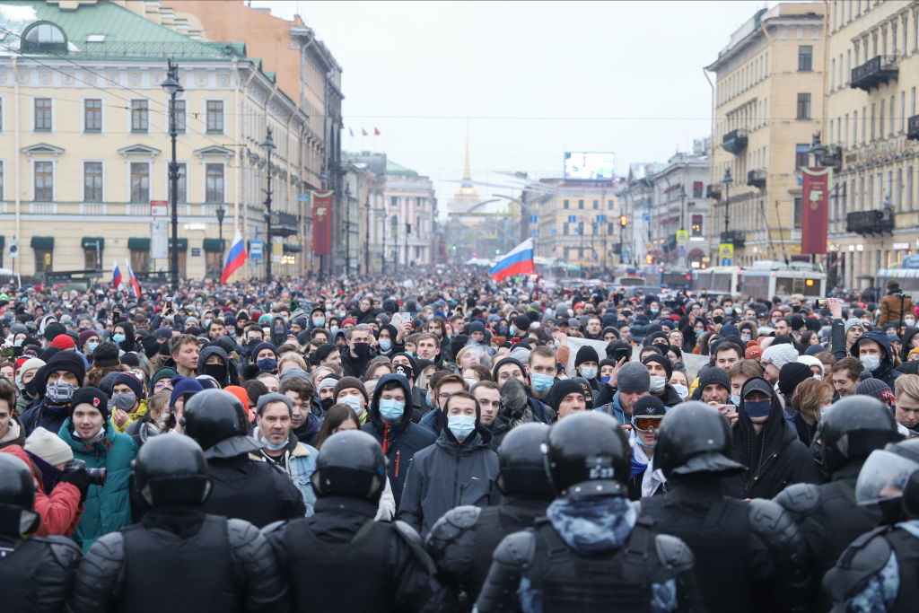 Police officers confront crowds of protesters during the