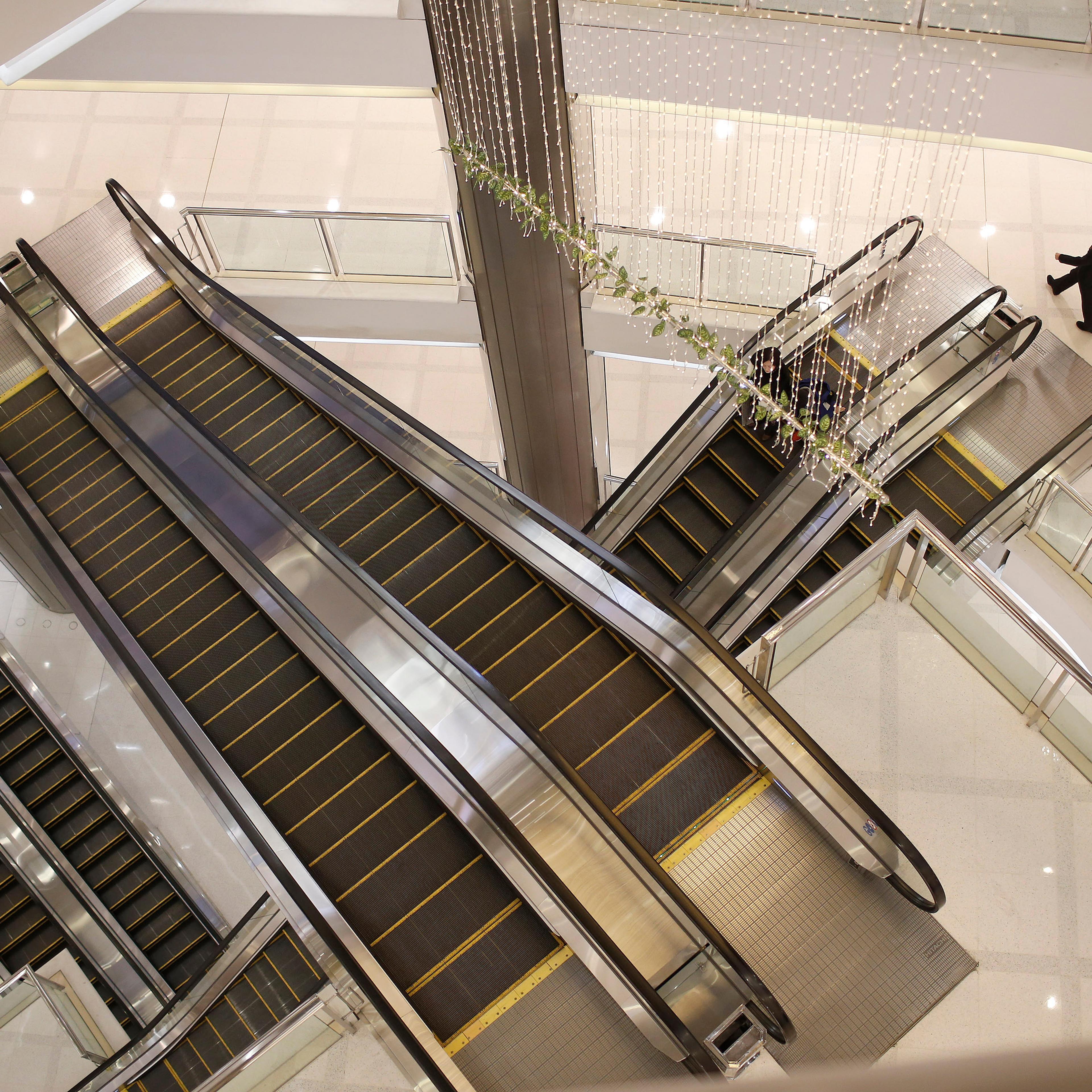 A woman walks next to escalators at a department store in Shanghai