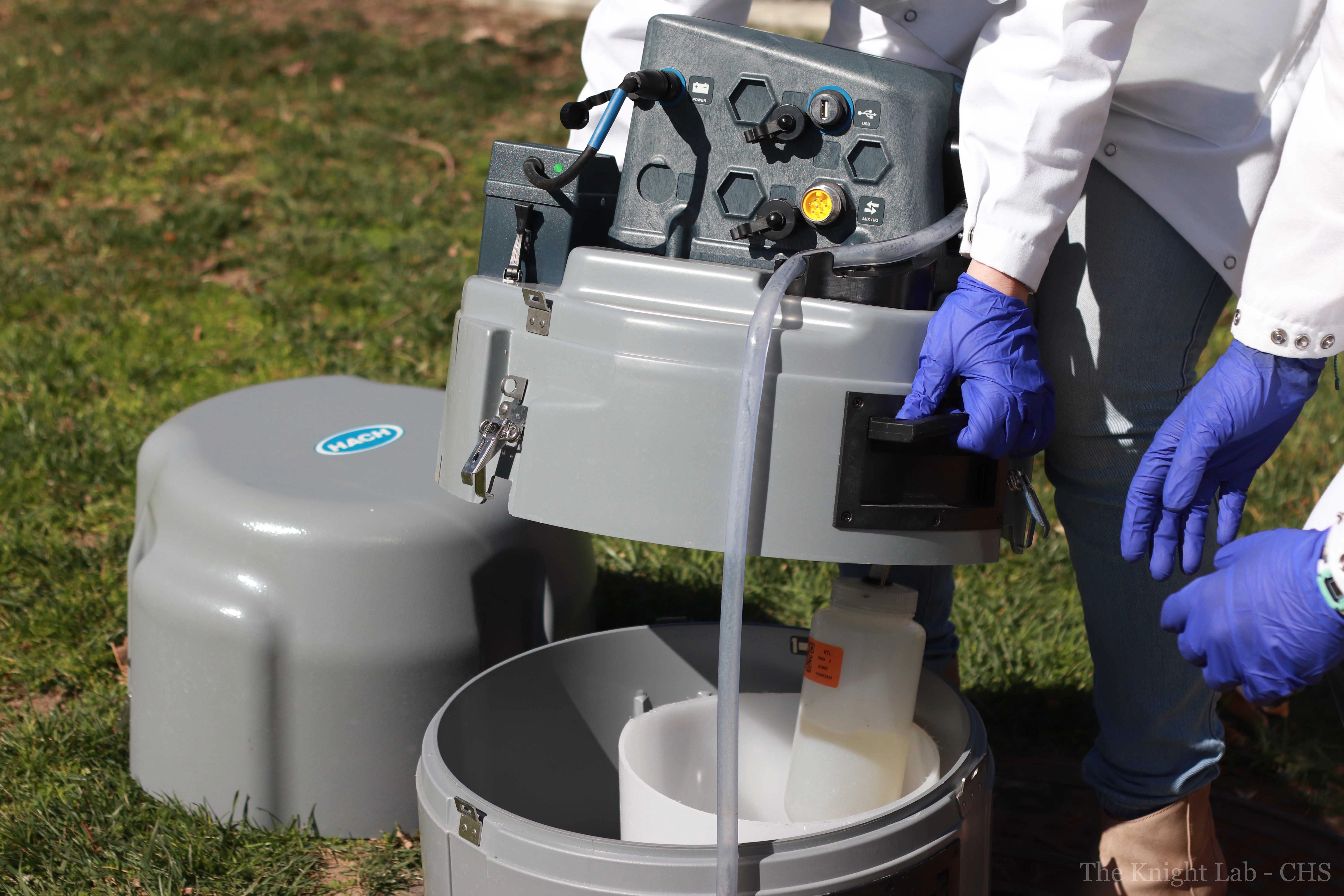 Researchers at UCSD prepare a robot sampler that collects wastewater from the university sewage system.