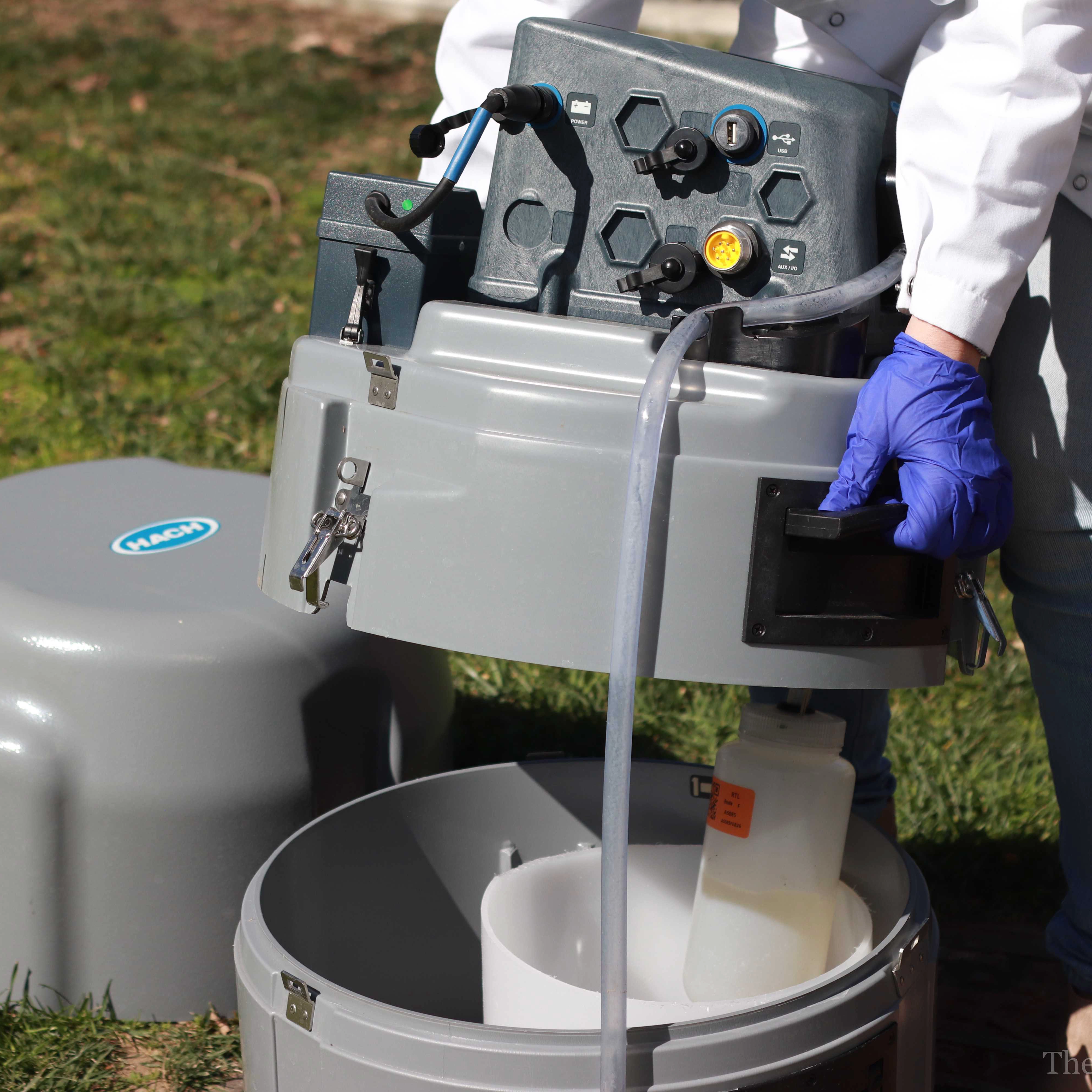 Researchers at UCSD prepare a robot sampler that collects wastewater from the university sewage system.