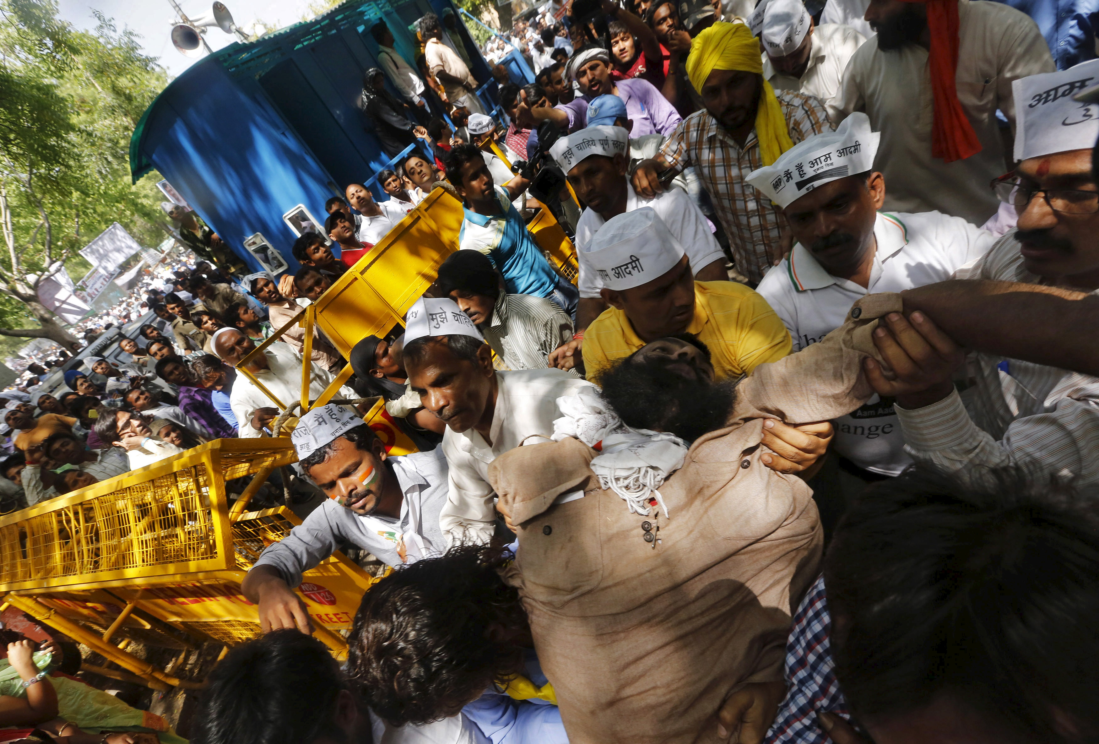 Protesters carry a farmer, who hung himself from a tree, towards an ambulance after being released from the tree during a rally organized by Aam Aadmi (Common Man) Party (AAP), in New Delhi