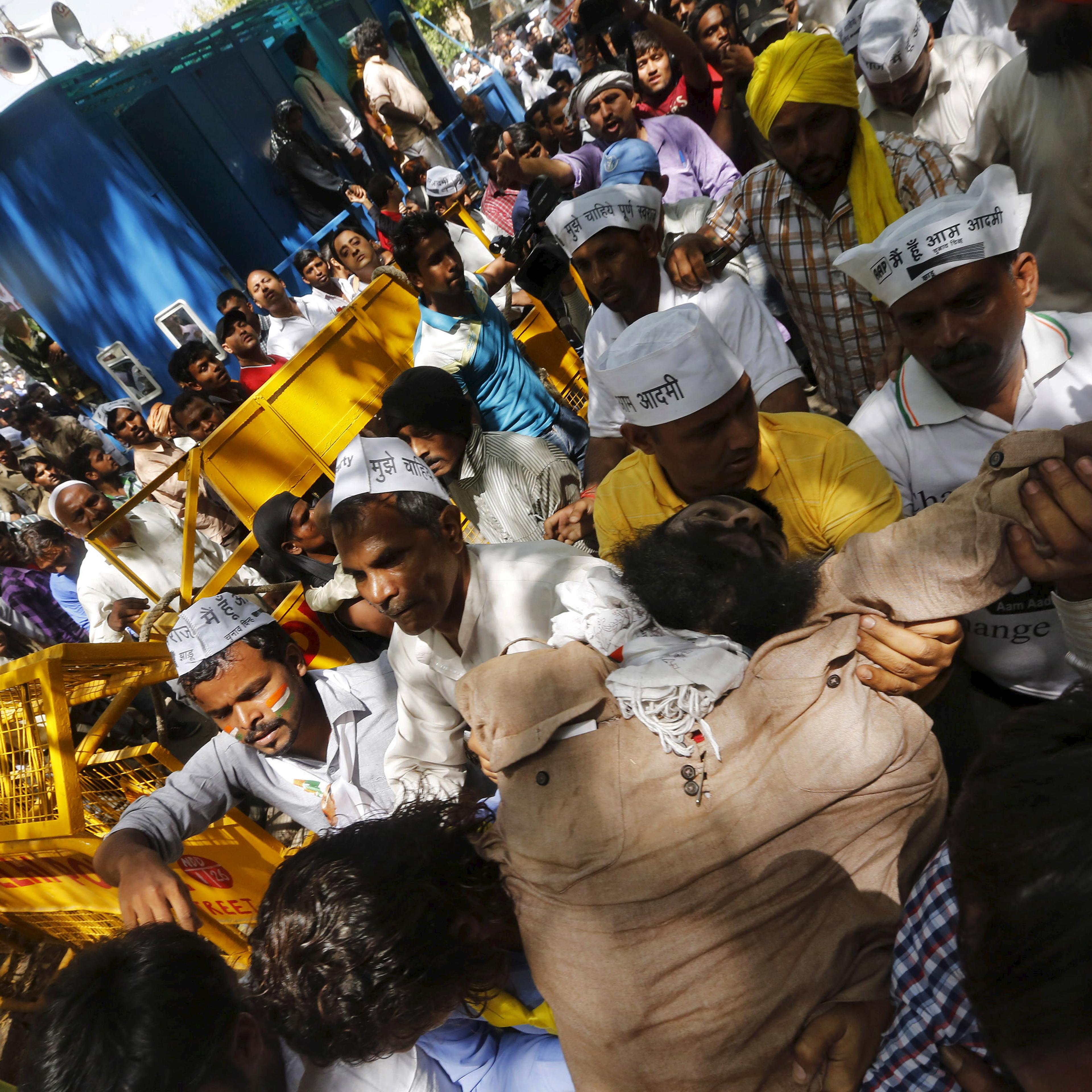 Protesters carry a farmer, who hung himself from a tree, towards an ambulance after being released from the tree during a rally organized by Aam Aadmi (Common Man) Party (AAP), in New Delhi