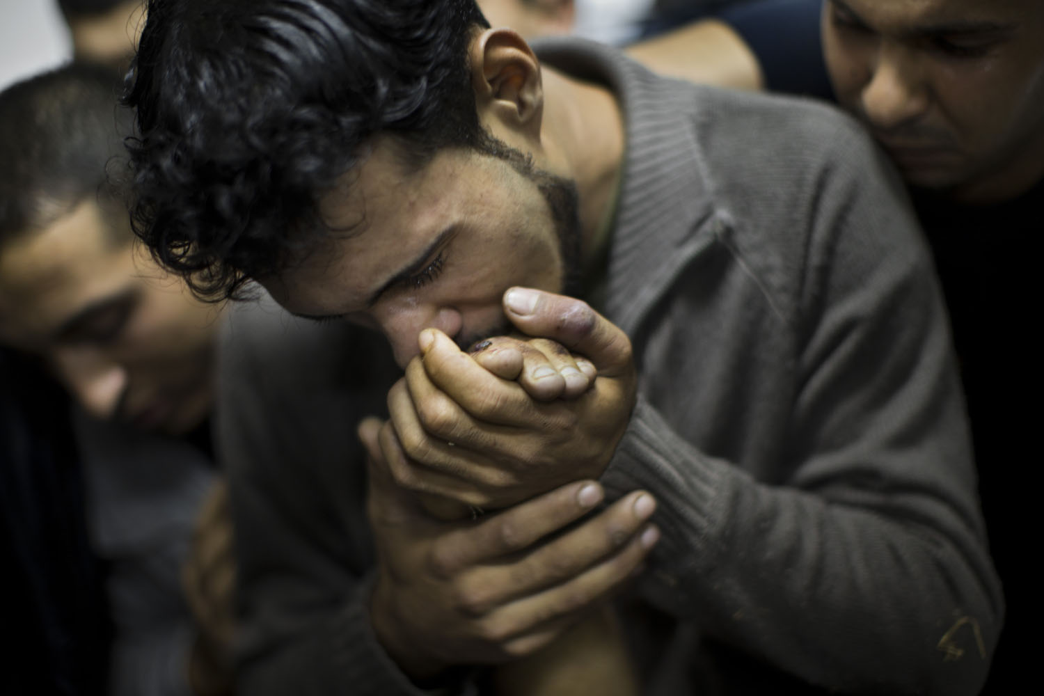 Nov. 18, 2012. A Palestinian man kisses the hand of a dead relative in the morgue of Shifa Hospital in Gaza City.