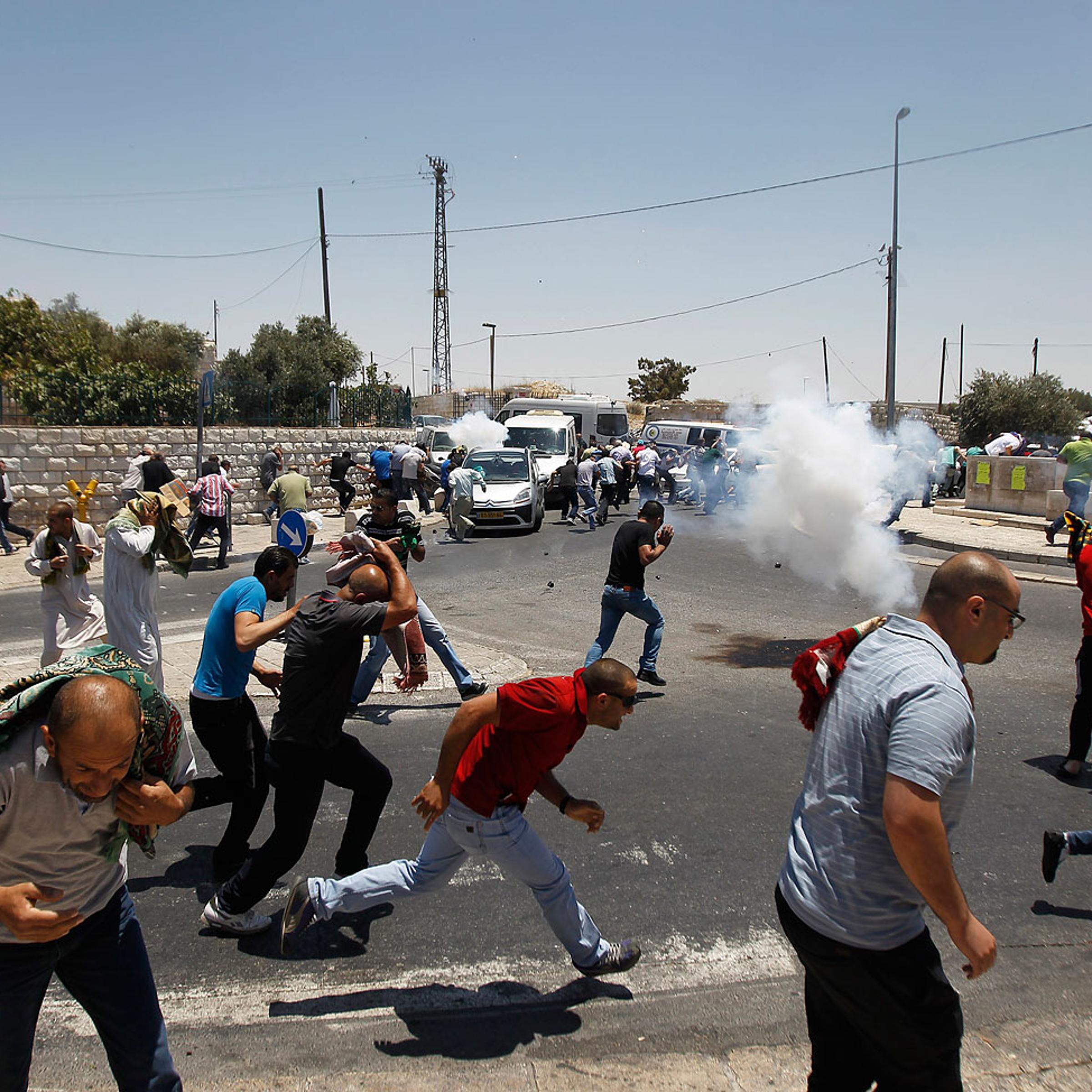 Palestinian protesters run away from tear gas in Ras al-Amud
