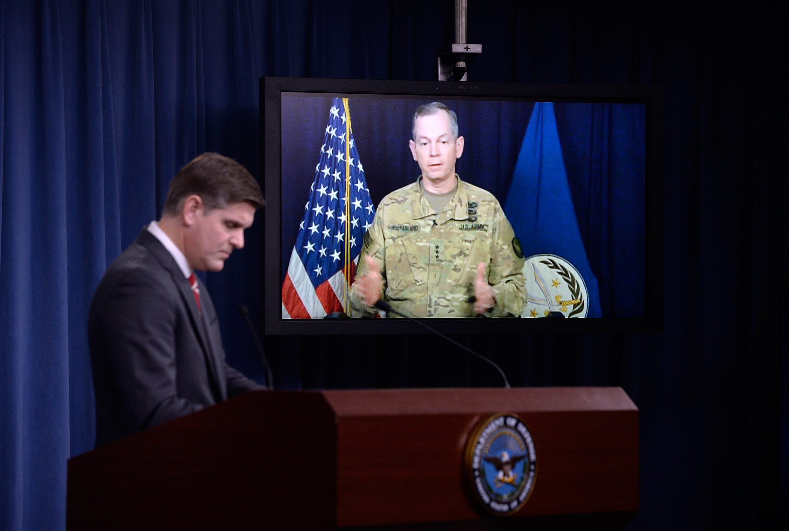 ARLINGTON, VA - FEBRUARY 1: Combined Joint Task Force Commander Army Lt. Gen. Sean MacFarland speaks via teleconference from Baghdad, Iraq as Pentagon Press Secretary Peter Cook listens during a media briefing at the Pentagon to update operations on Oper