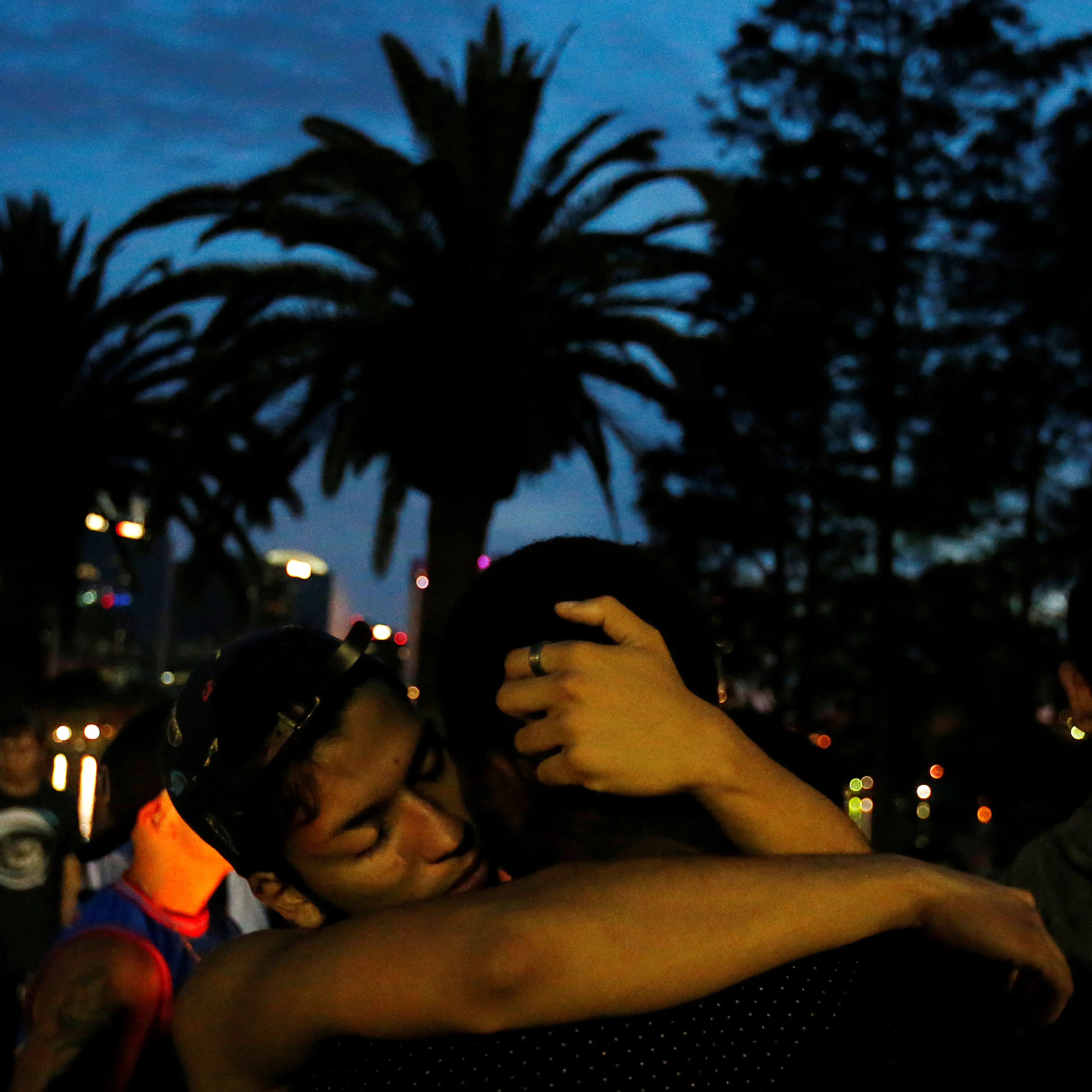 Men hug during a vigil in a park following a mass shooting at the Pulse gay nightclub in Orlando Florida, U.S. June 12, 2016. REUTERS/Carlo Allegri - RTX2FURO