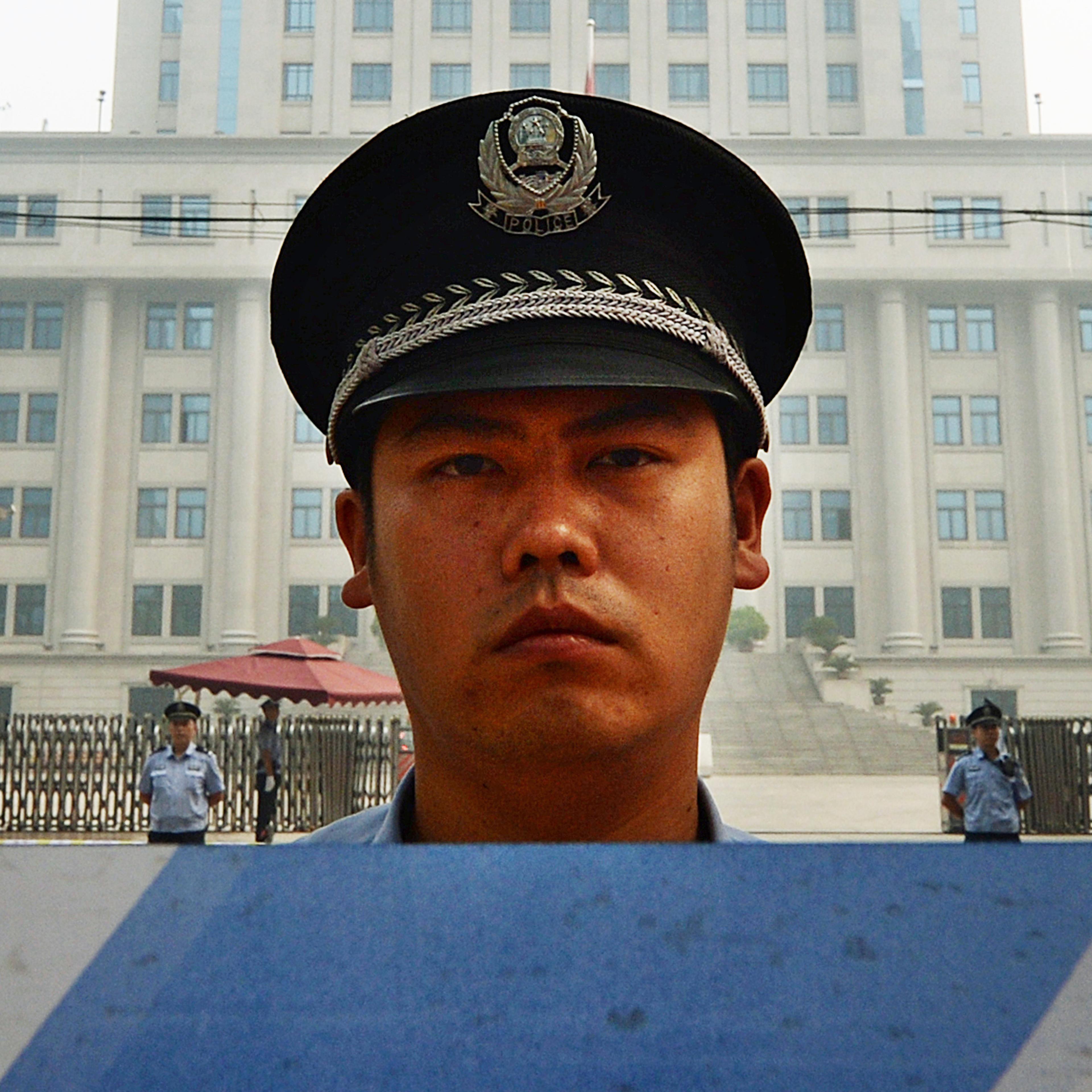 Police stand guard during the third day of the trial of disgraced official Bo Xilai at the Intermediate People's Court in Jinan, Shandong province, on Aug. 24, 2013.