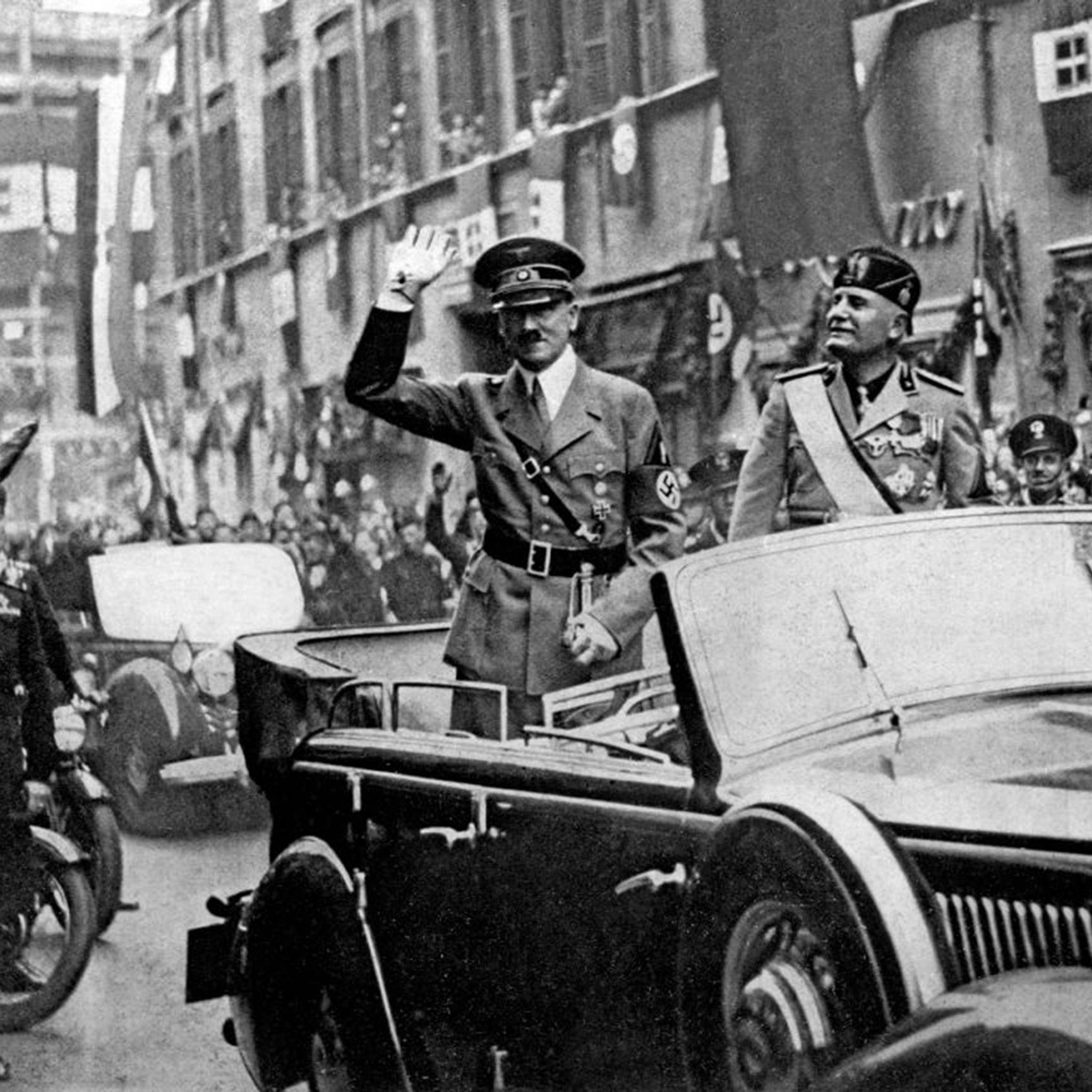 Adolf Hitler (left) and Benito Mussolini in a car, saluting the crowd that gathered along the thoroughfare Corso Vittorio Emanuele in Rome, in May 1938.