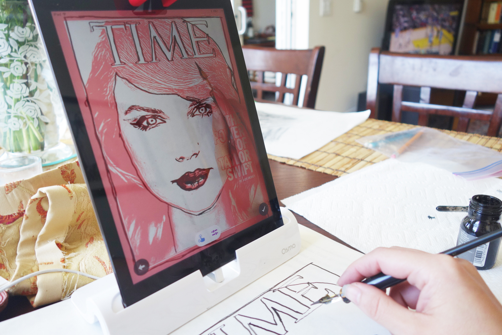 Osmo's Masterpiece app breaks down images into lines that the user can trace, watching their own hand move across the page on the screen. This picture shows the author copying a TIME cover featuring Taylor Swift. Notice the image of her hand and pen on the screen.  